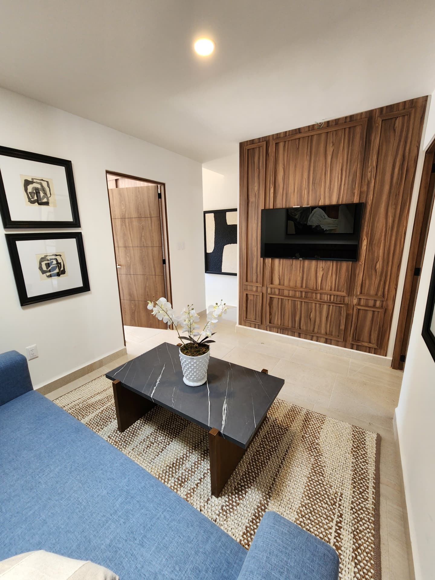 Sala de TV con muro de madera y panel para pantalla