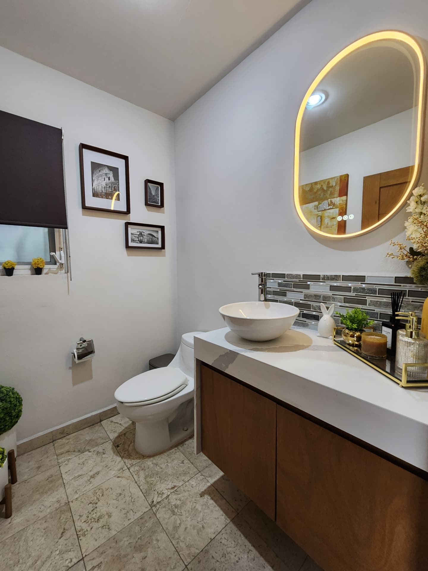 Medio baño con lavabo sobrepuesto, espejo retroiluminado y carpintería de madera