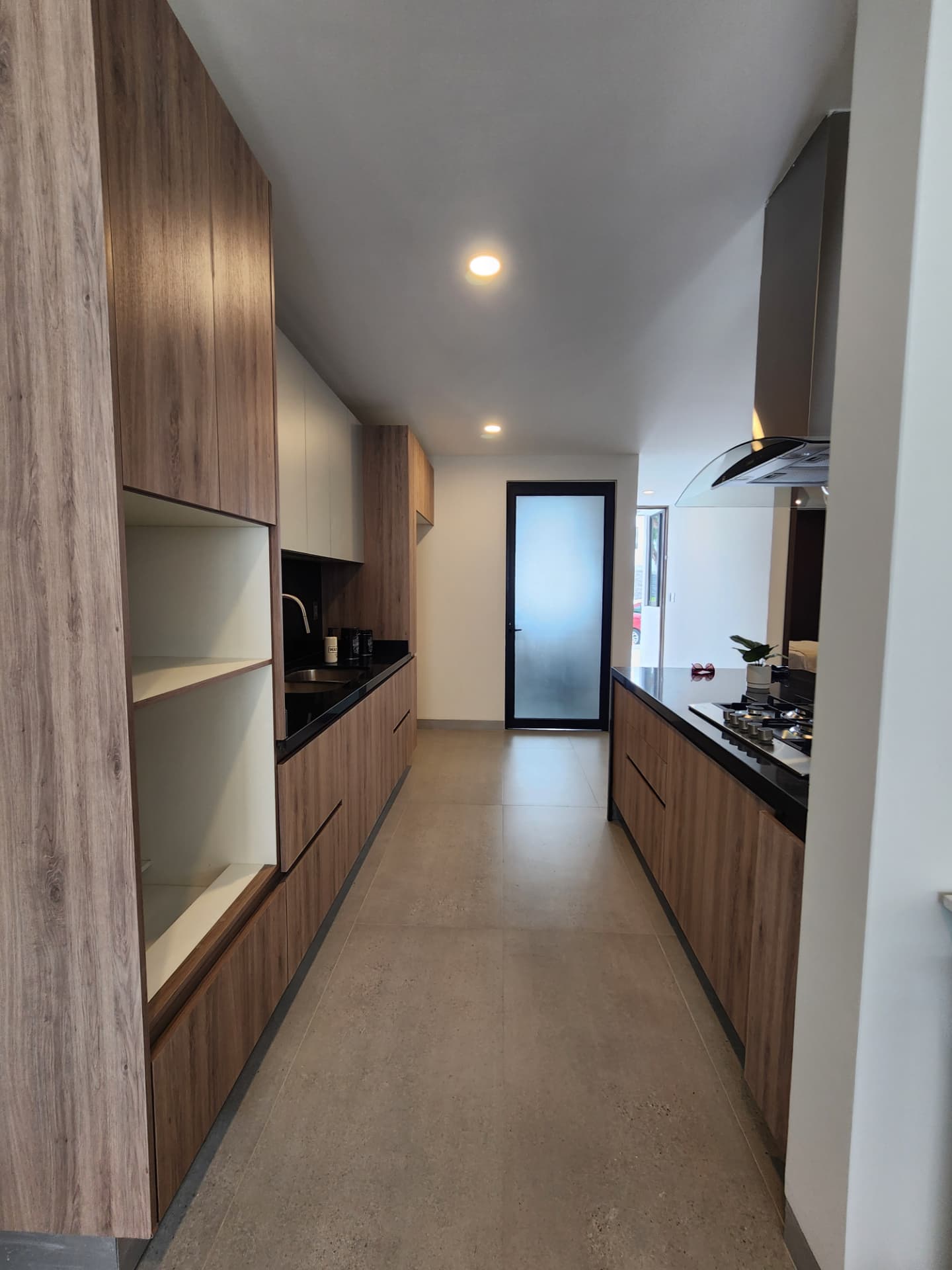Cocina equipada con cubierta de granito y campana