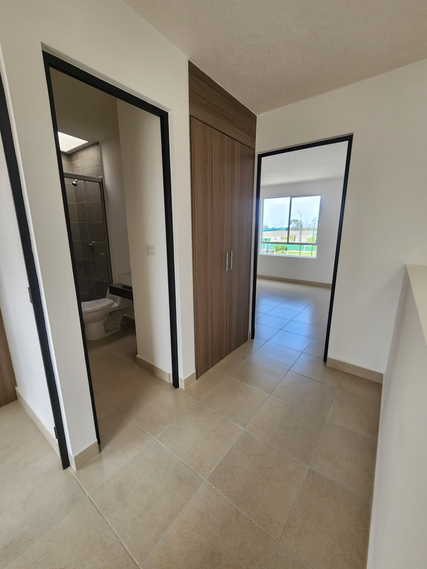 Distribuidor del segundo nivel con closet de blancos y acceso a baño