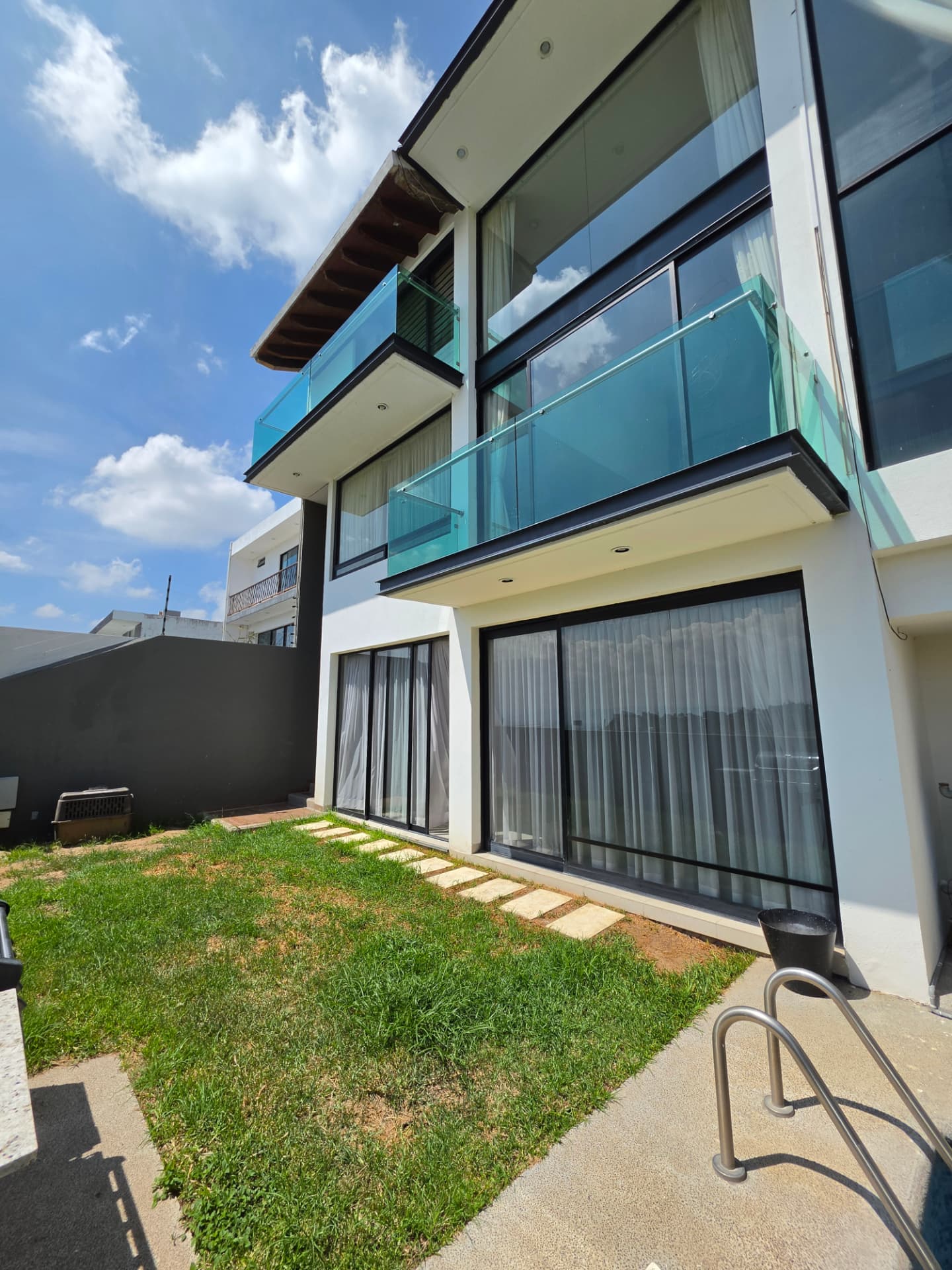 Fachada posterior con balcones de cristal