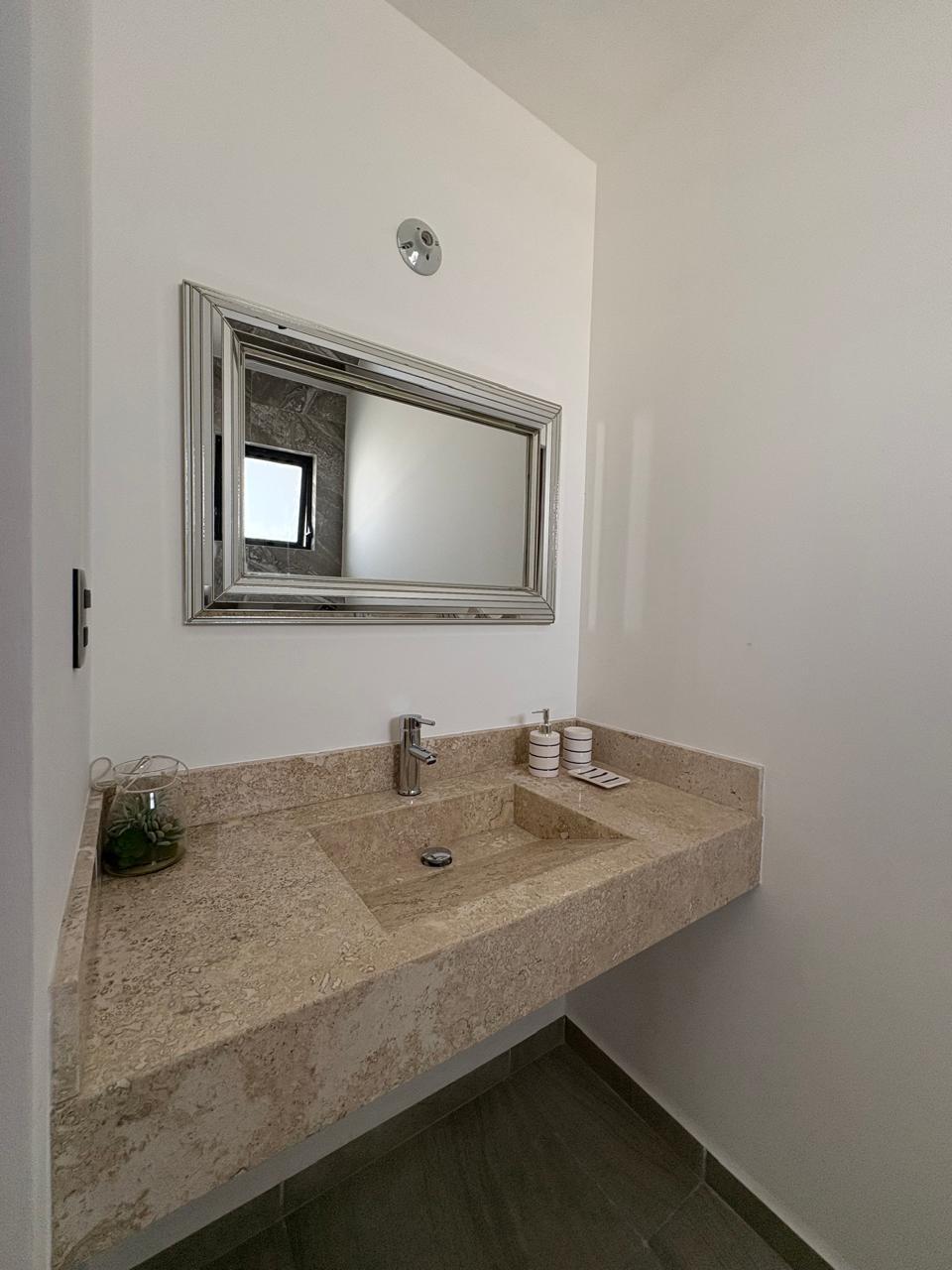 Medio baño con lavabo de mármol y espejo
