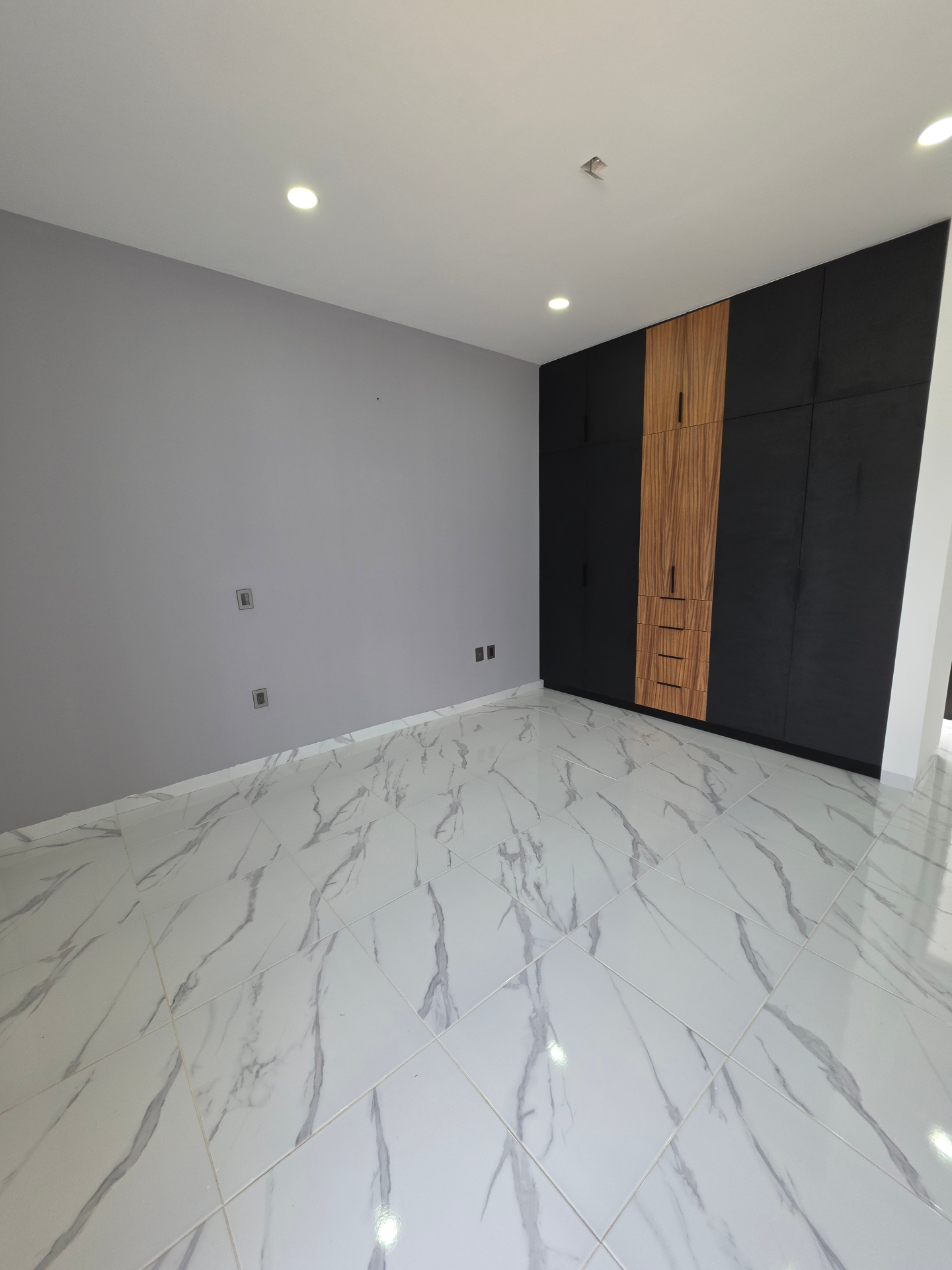 Segundo ángulo del baño con acabados premium en negro, blanco y madera