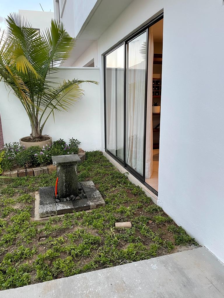 Jardín trasero con fuente y acceso desde el comedor
