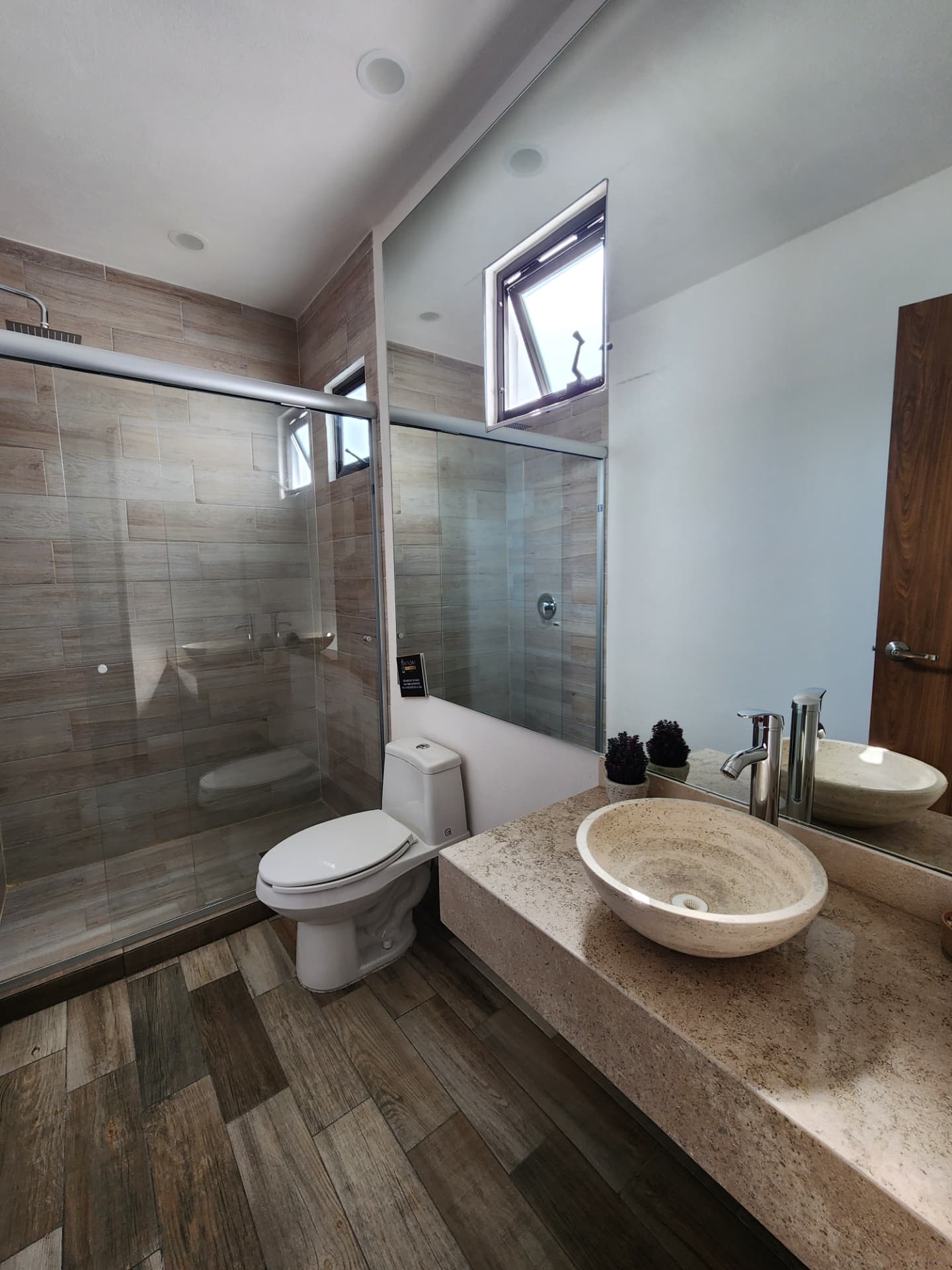 Baño principal con regadera de cristal y ovalín de cantera