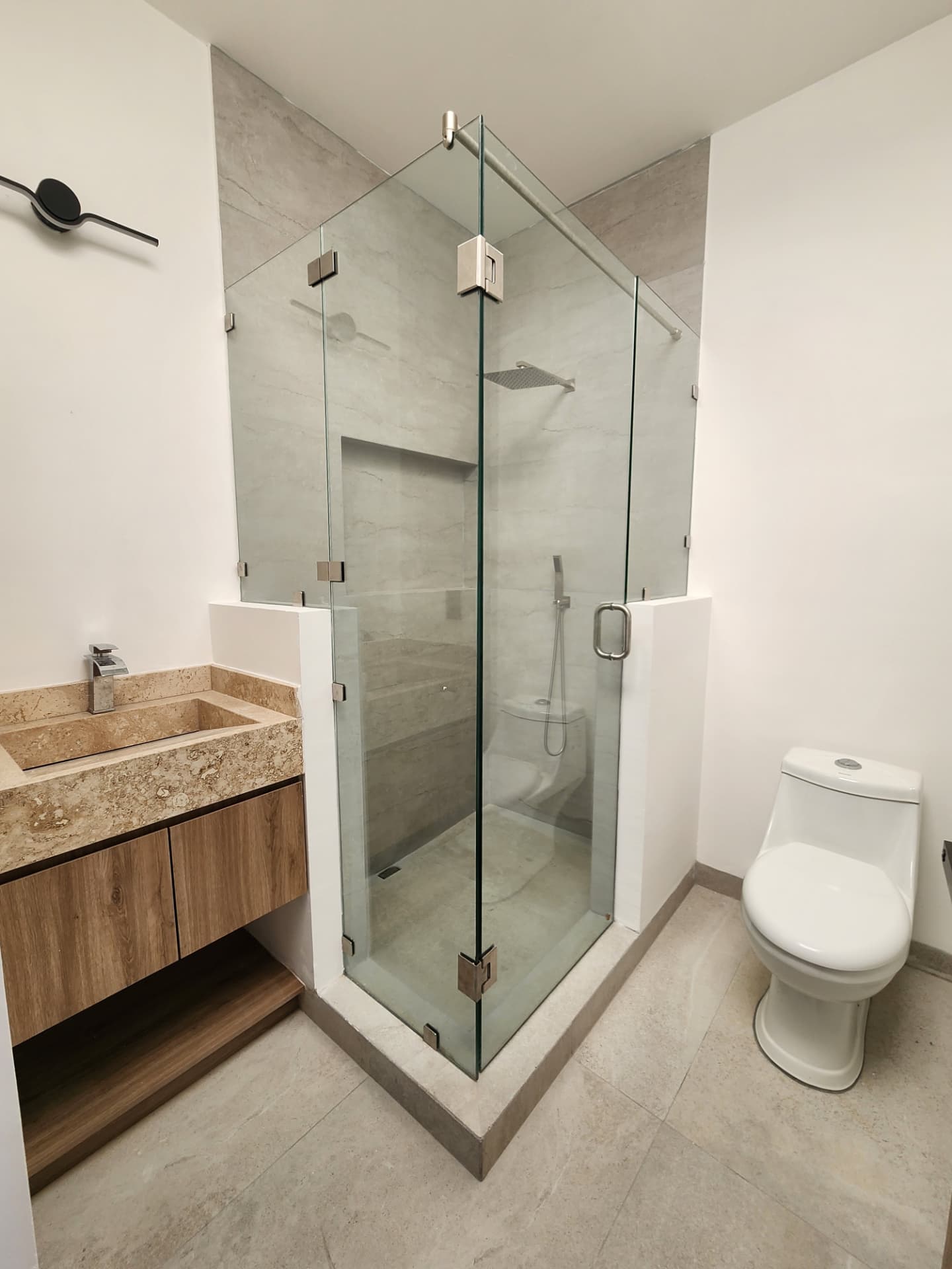 Baño completo con cancel de cristal templado y cubierta de mármol travertino