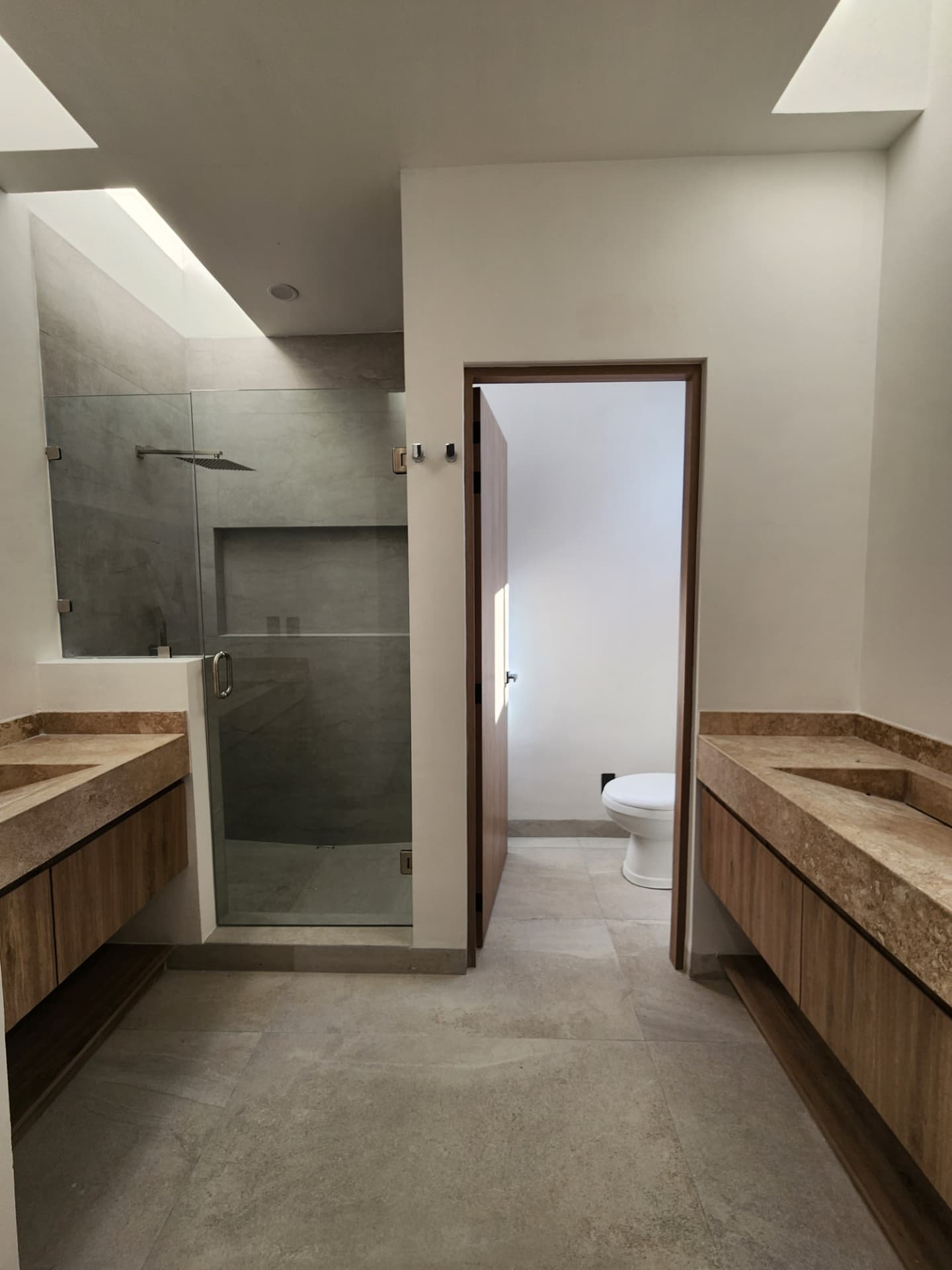 Baño principal con doble lavabo, tragaluz y regadera con cancel