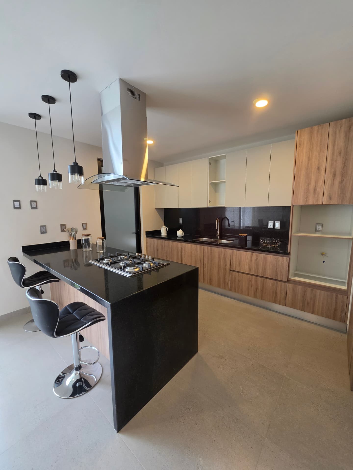 Cocina con barra, parrilla de gas y campana de isla