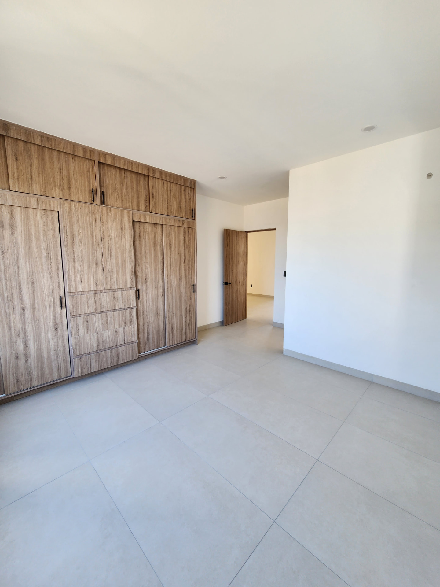 Recámara con closet de madera de piso a techo