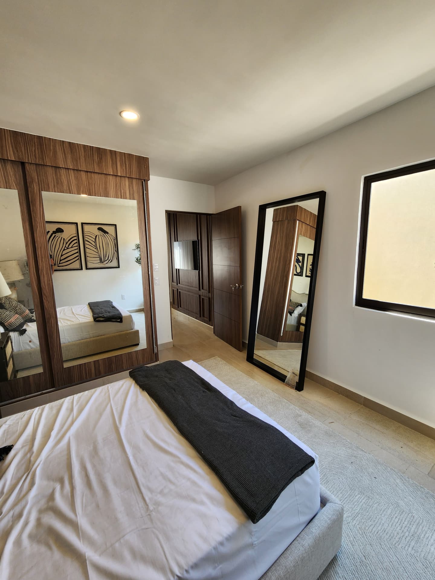 Recámara con closet de puertas espejadas y espejo de piso