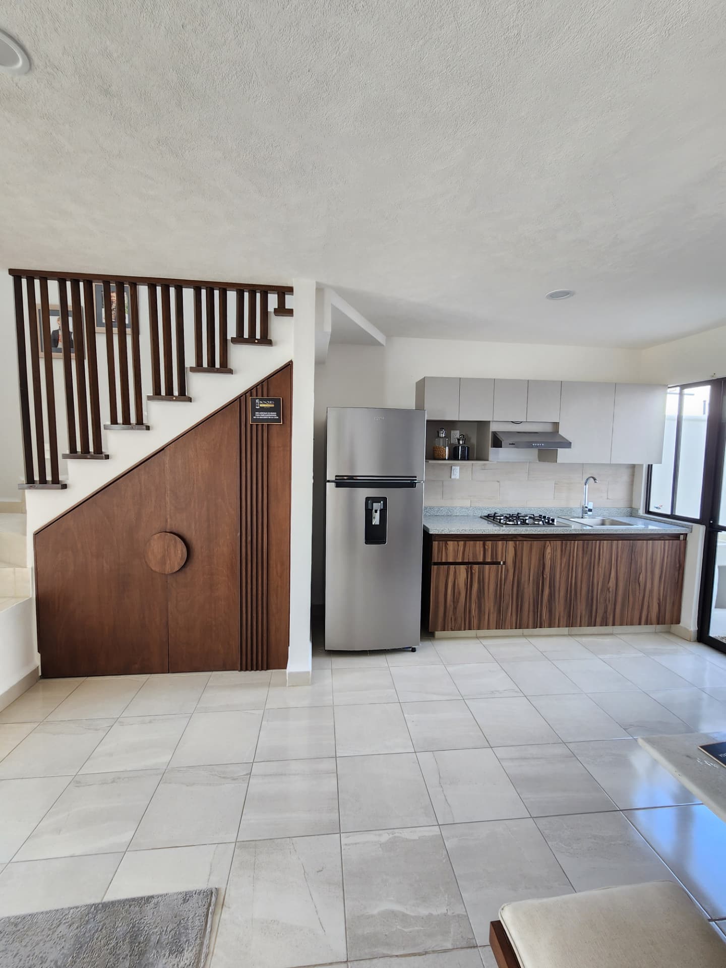 Cocina integrada con escalera y almacenaje de madera