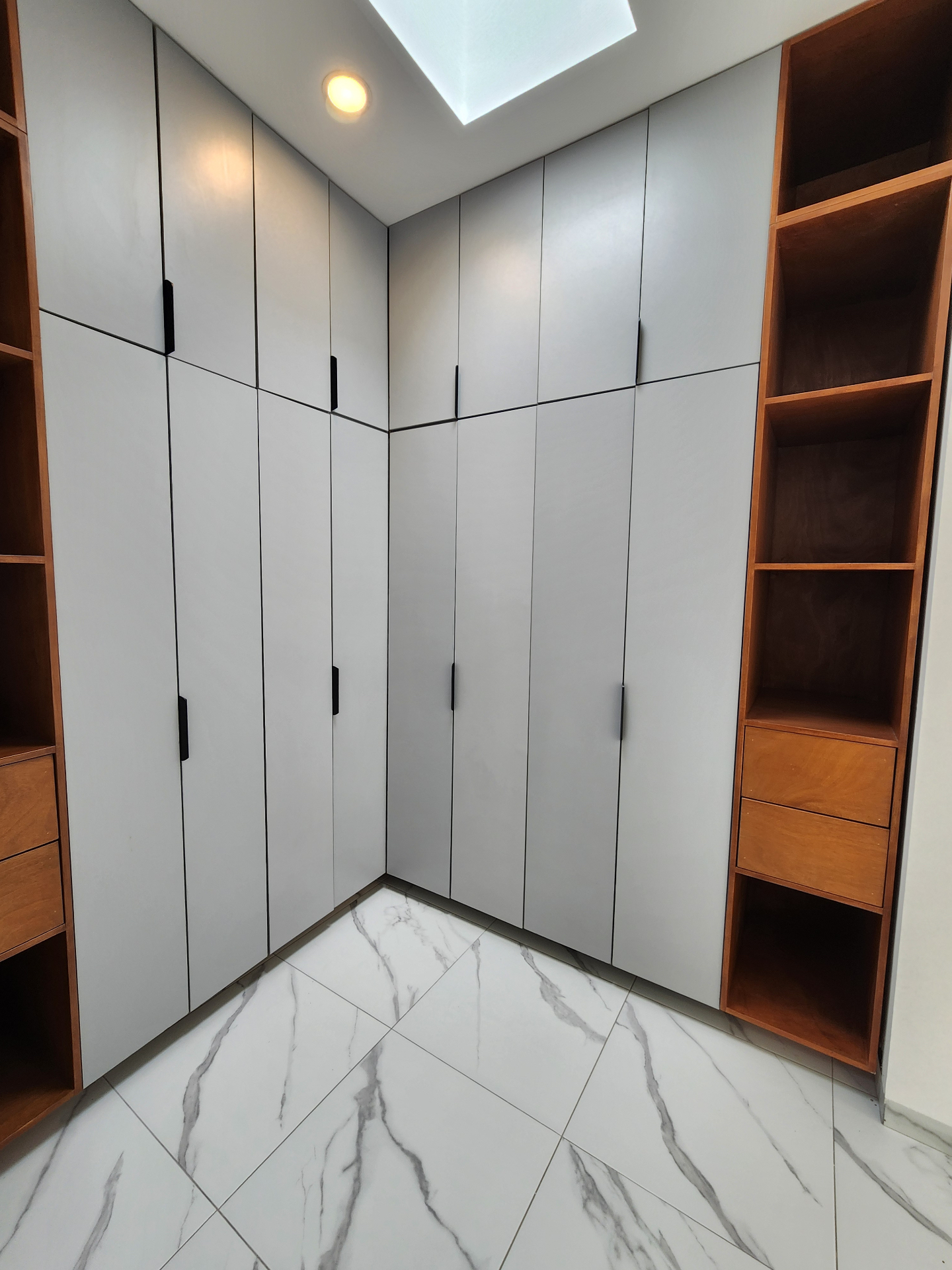 Vestidor con closets de piso a techo, cajoneras y tragaluz