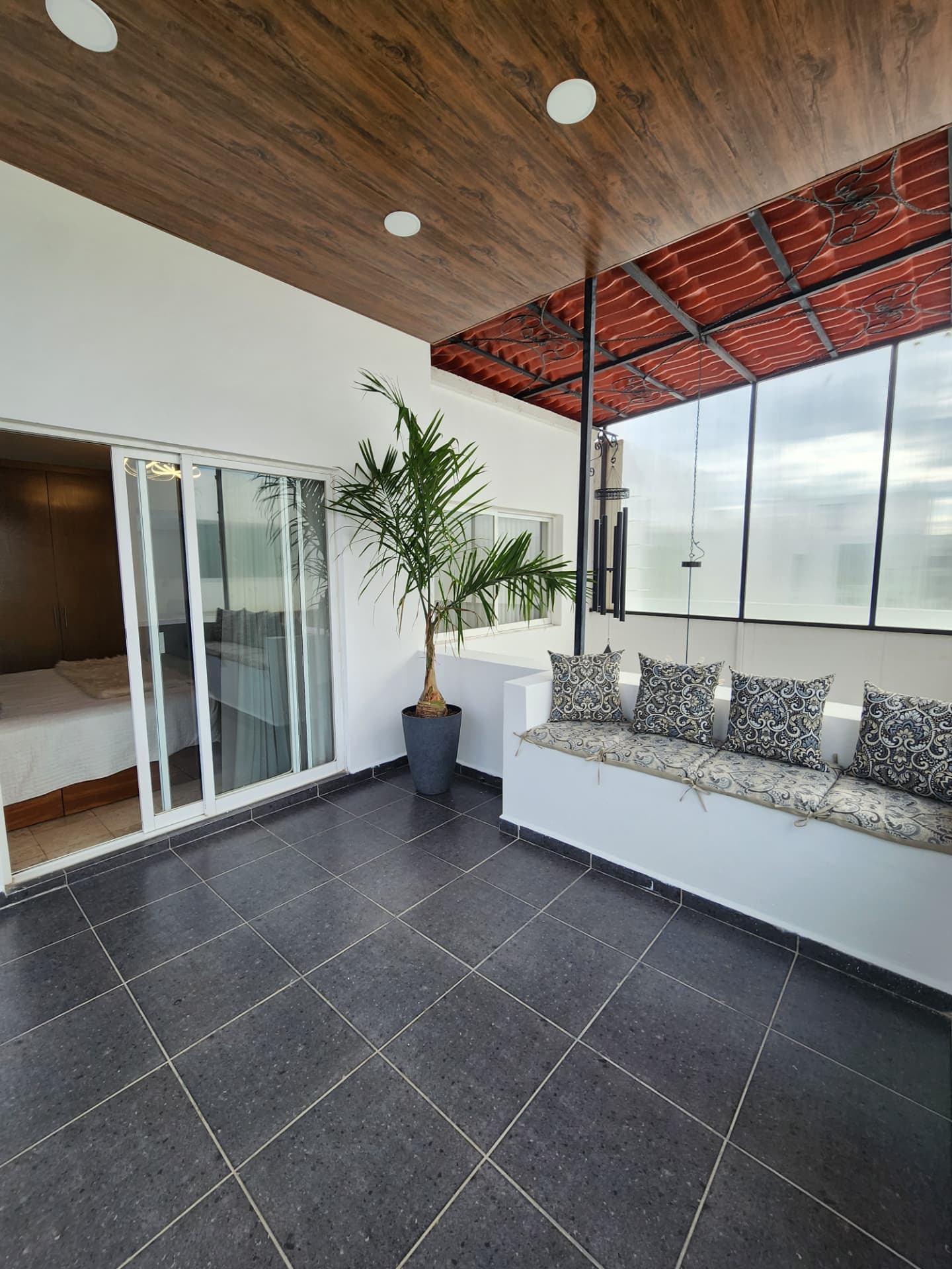 Terraza techada con banca integrada y acceso a recámara principal