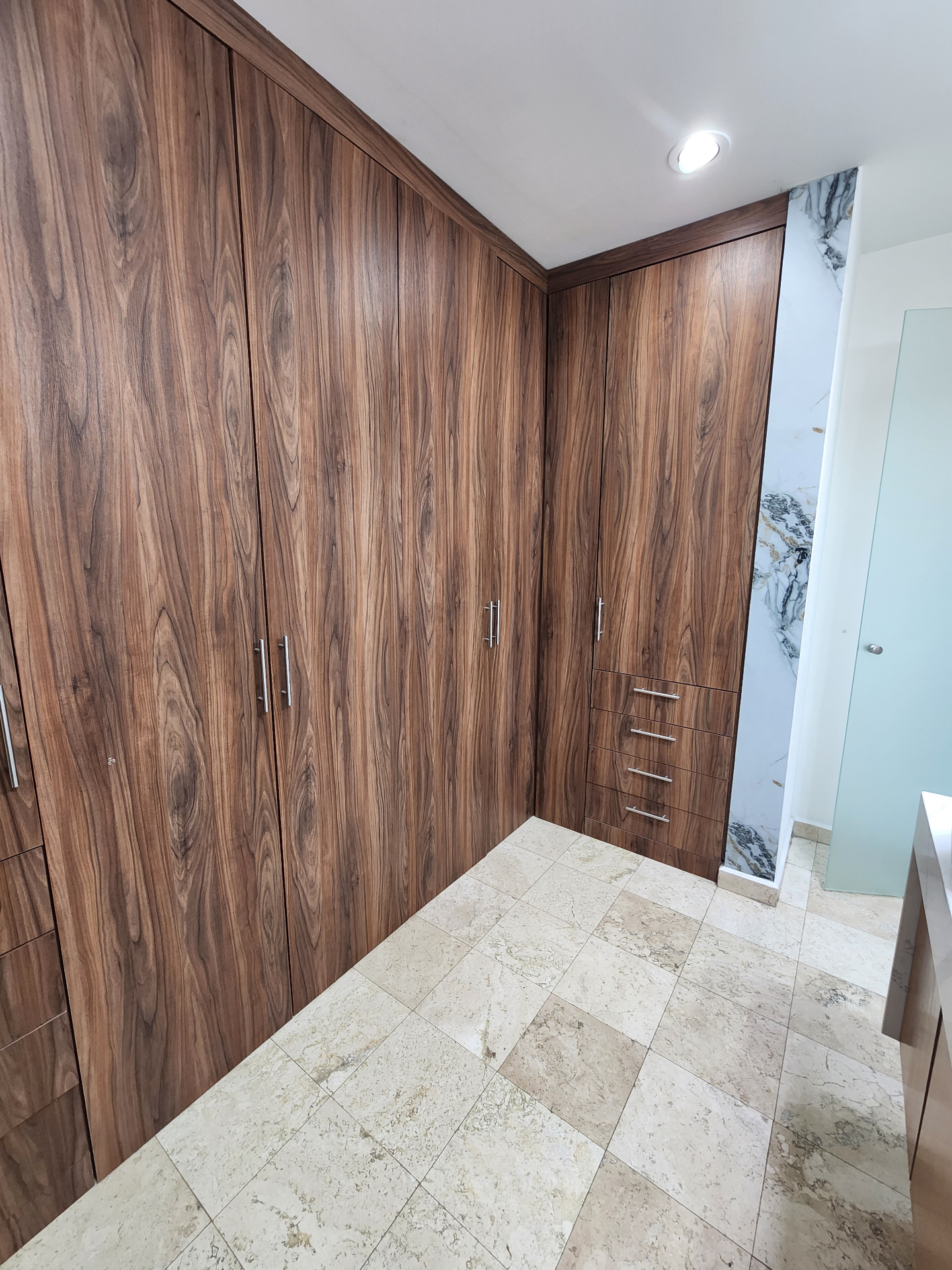 Vestidor con carpintería de madera de piso a techo y cajoneras integradas