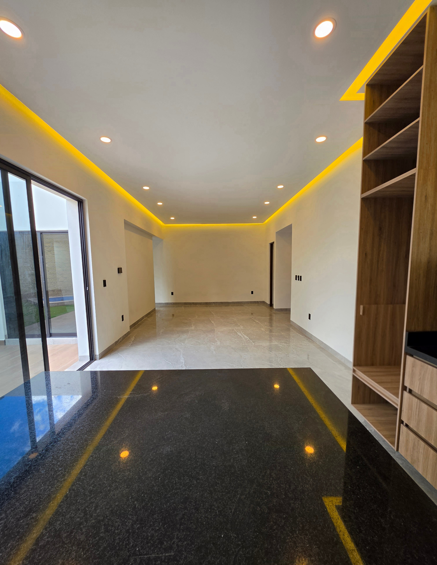 Interior con doble tono de piso, mueble de madera integrado y luz cálida