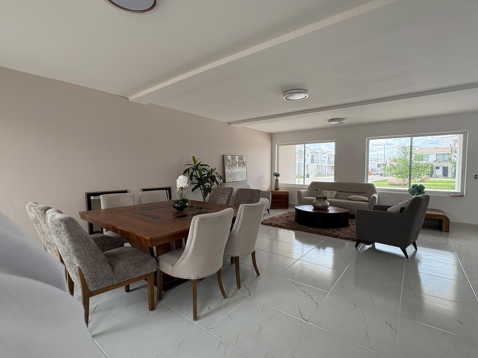 Sala y comedor integrados con doble ventanal