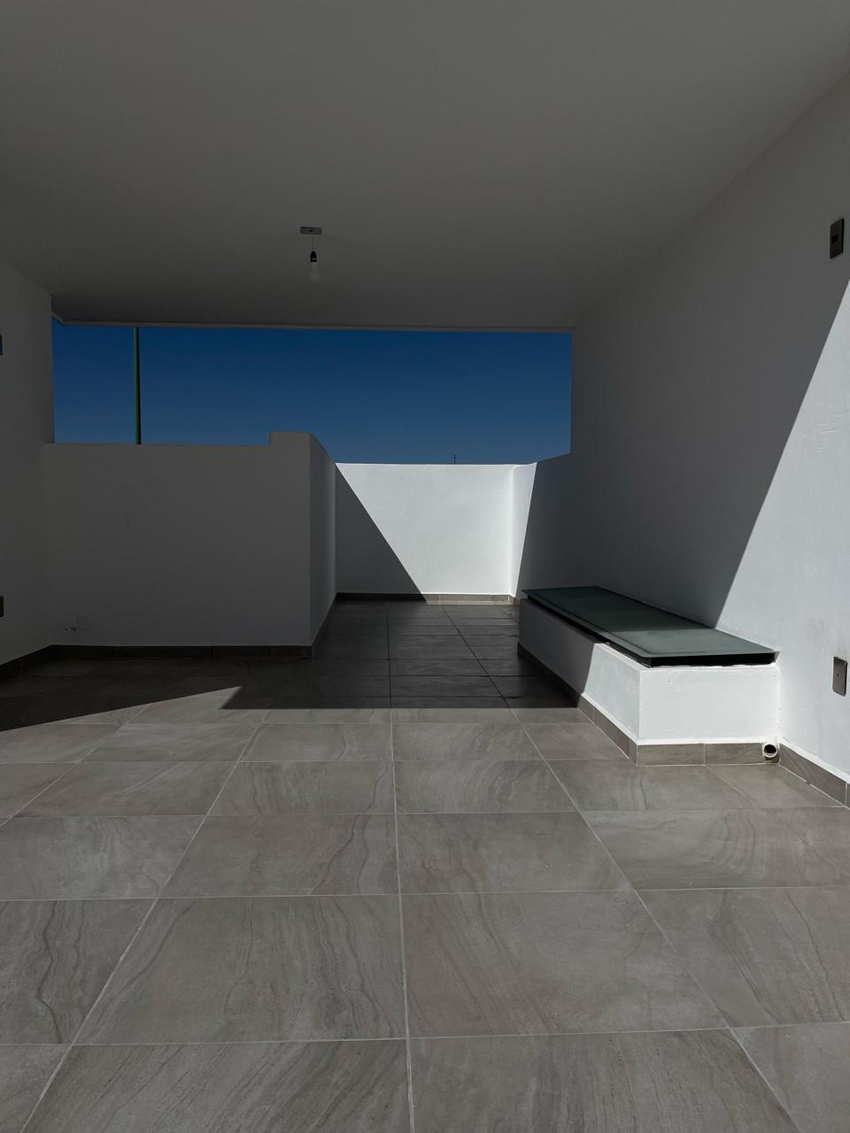 Roof garden con banca de concreto y cristal