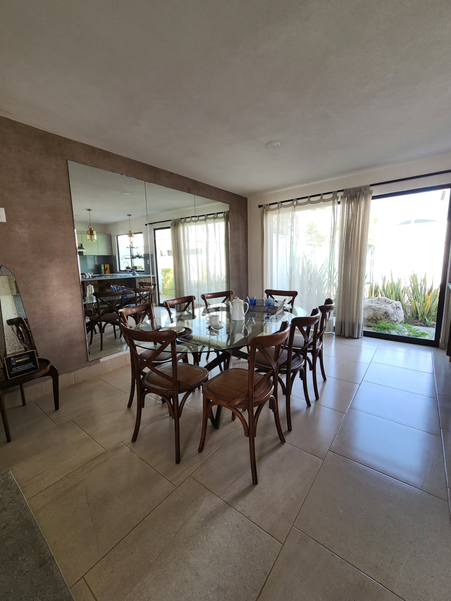 Comedor con muro de espejos y ventanales al jardín