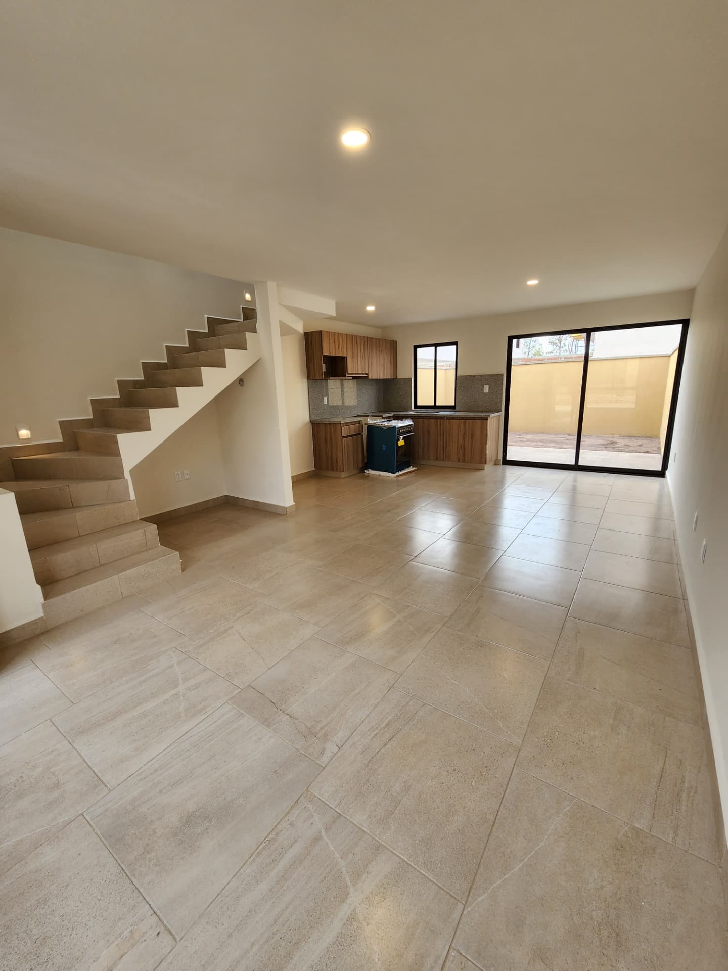 Sala / comedor integrado a la cocina con ventanal al jardín
