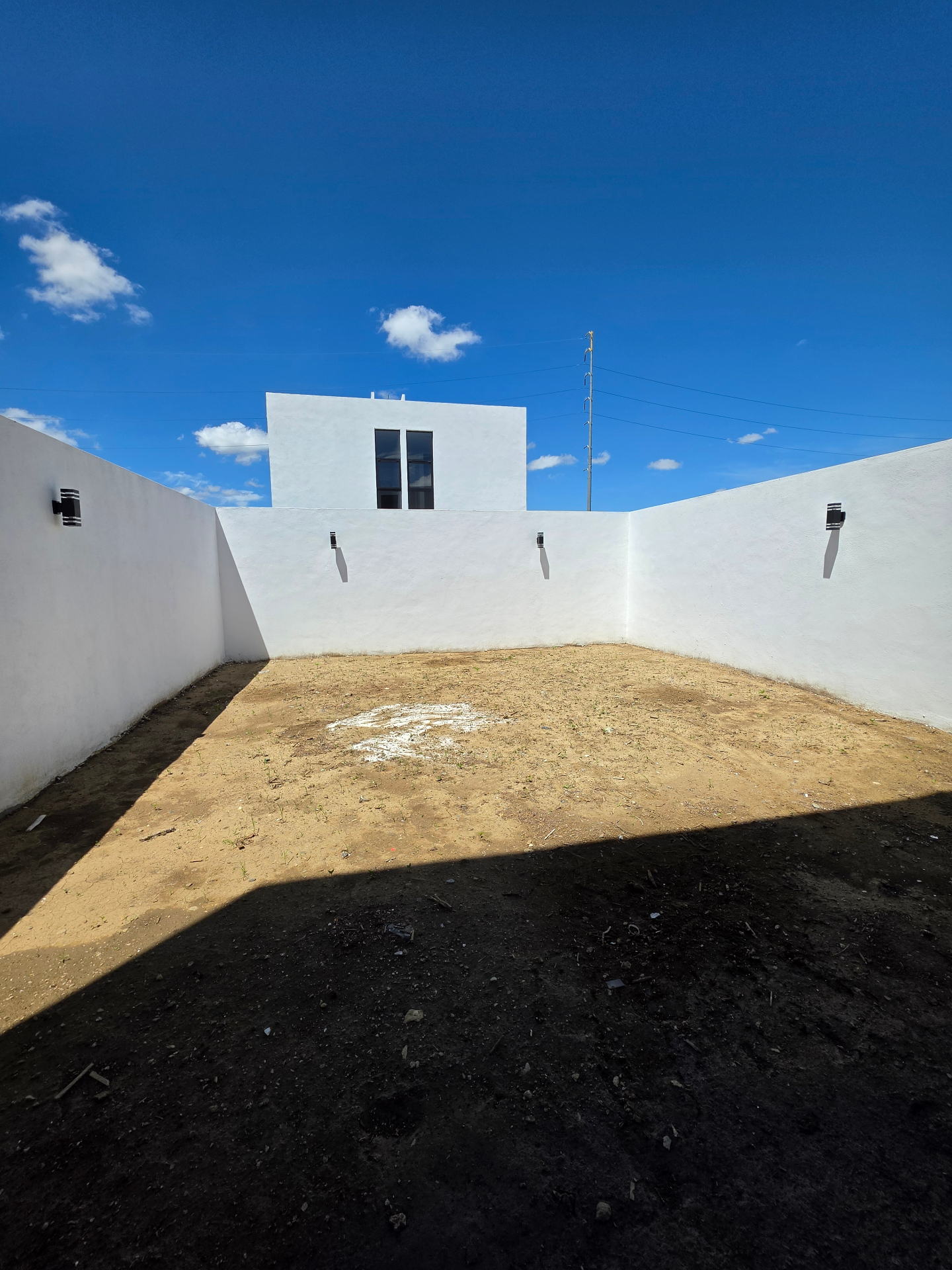 Jardín trasero privado con muros altos