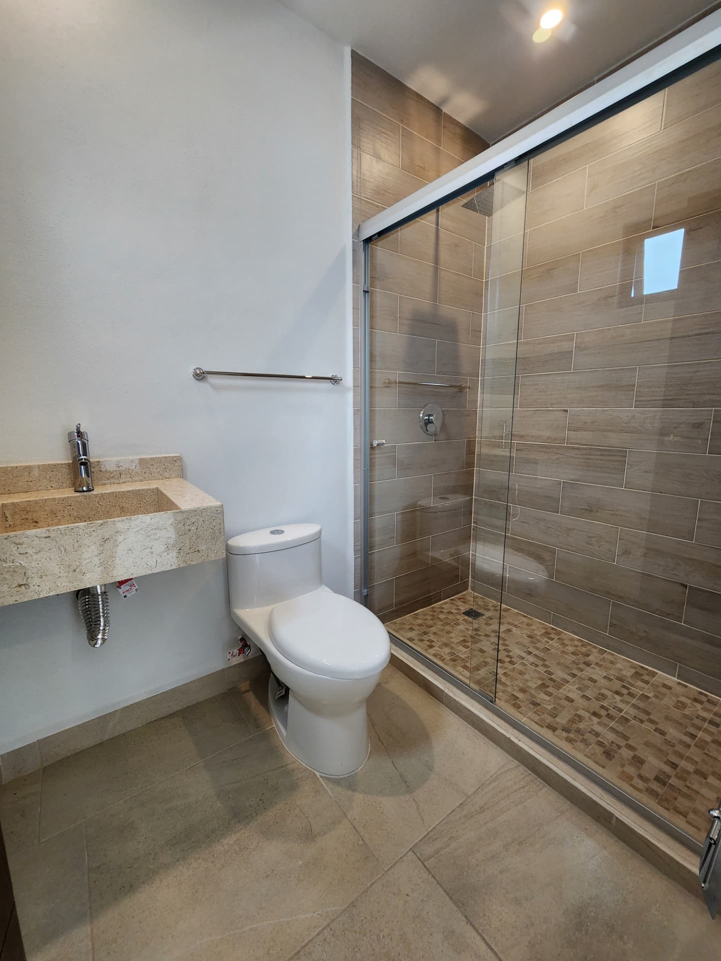 Baño completo con regadera de cristal y lavabo de mármol