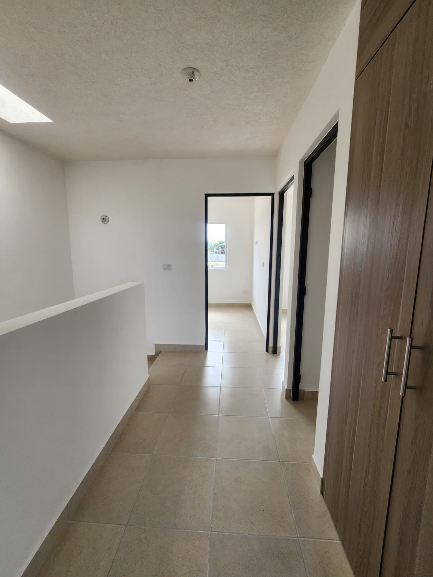 Pasillo del segundo nivel con tragaluz y acceso a recámaras