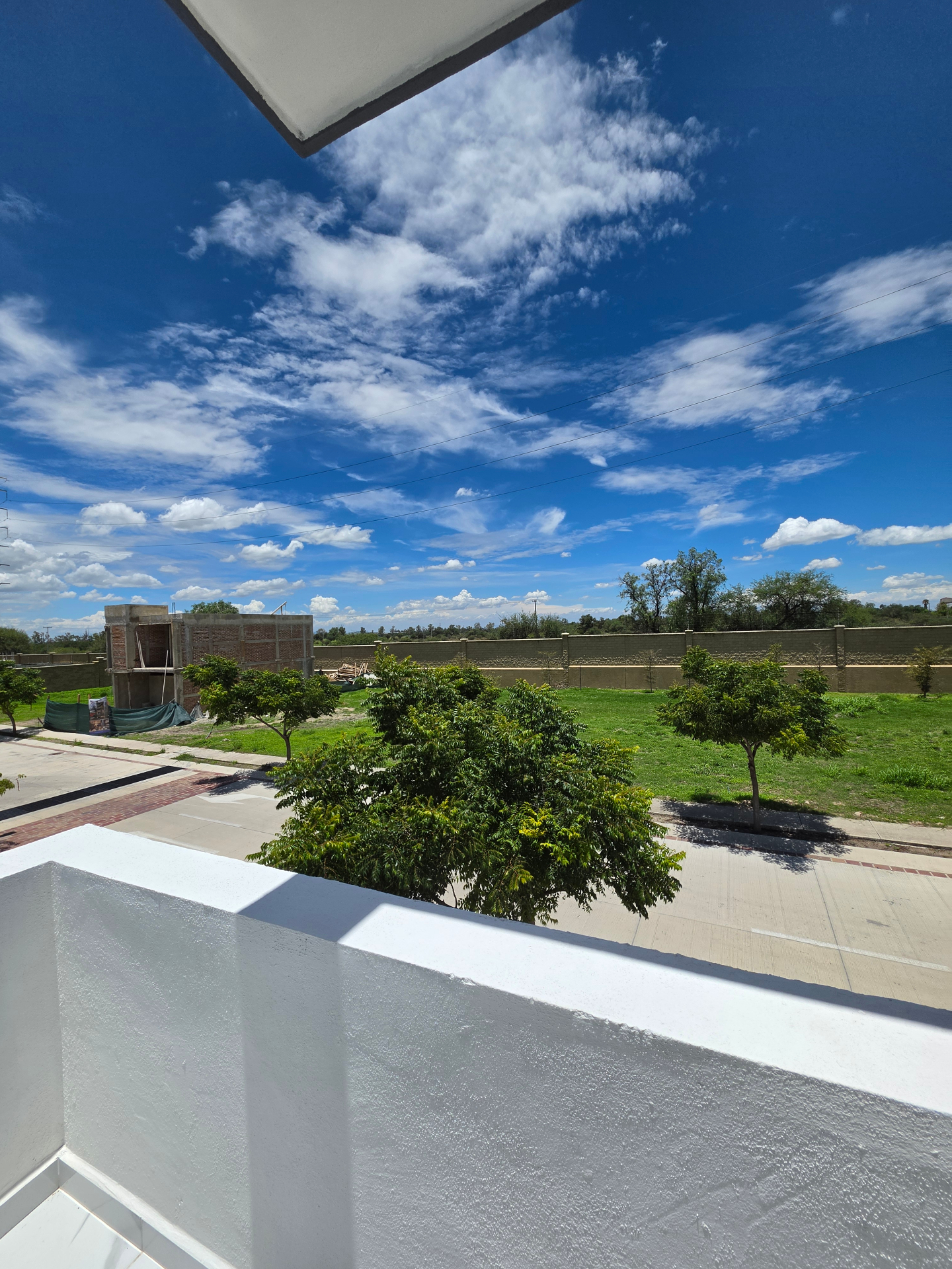 Balcón con vista despejada al área verde y cielo abierto