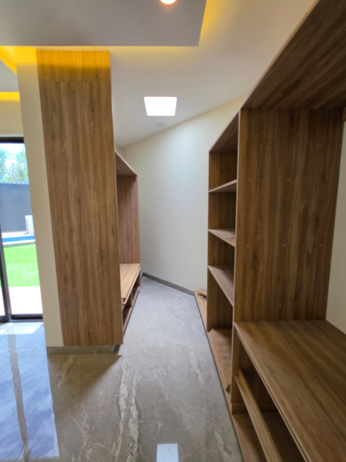 Vestidor amplio con módulos de madera y luz natural