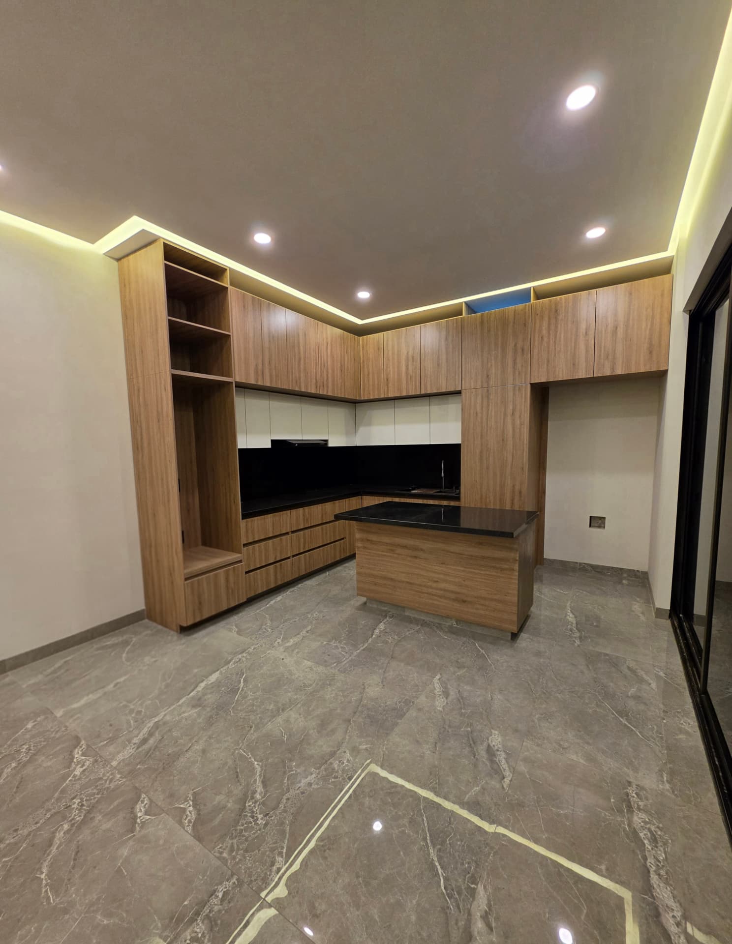 Cocina con muebles de madera de piso a techo y luz LED perimetral