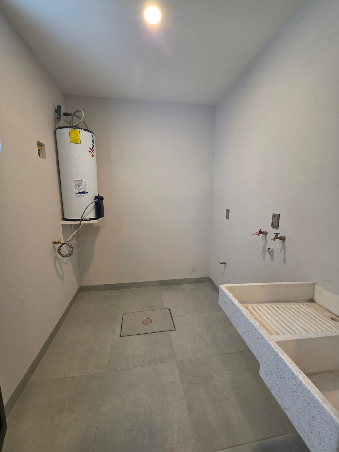 Cuarto de lavado con lavadero y boiler instalado