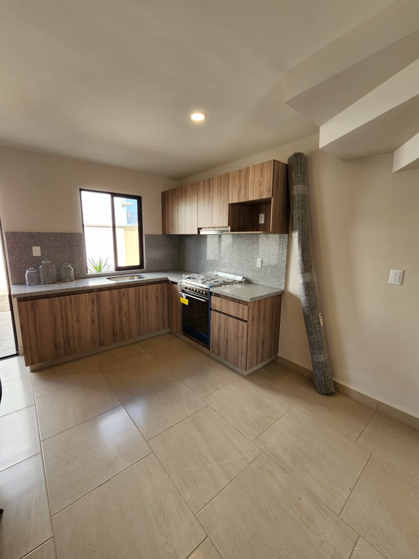 Cocina en L con alacenas de madera y luz natural