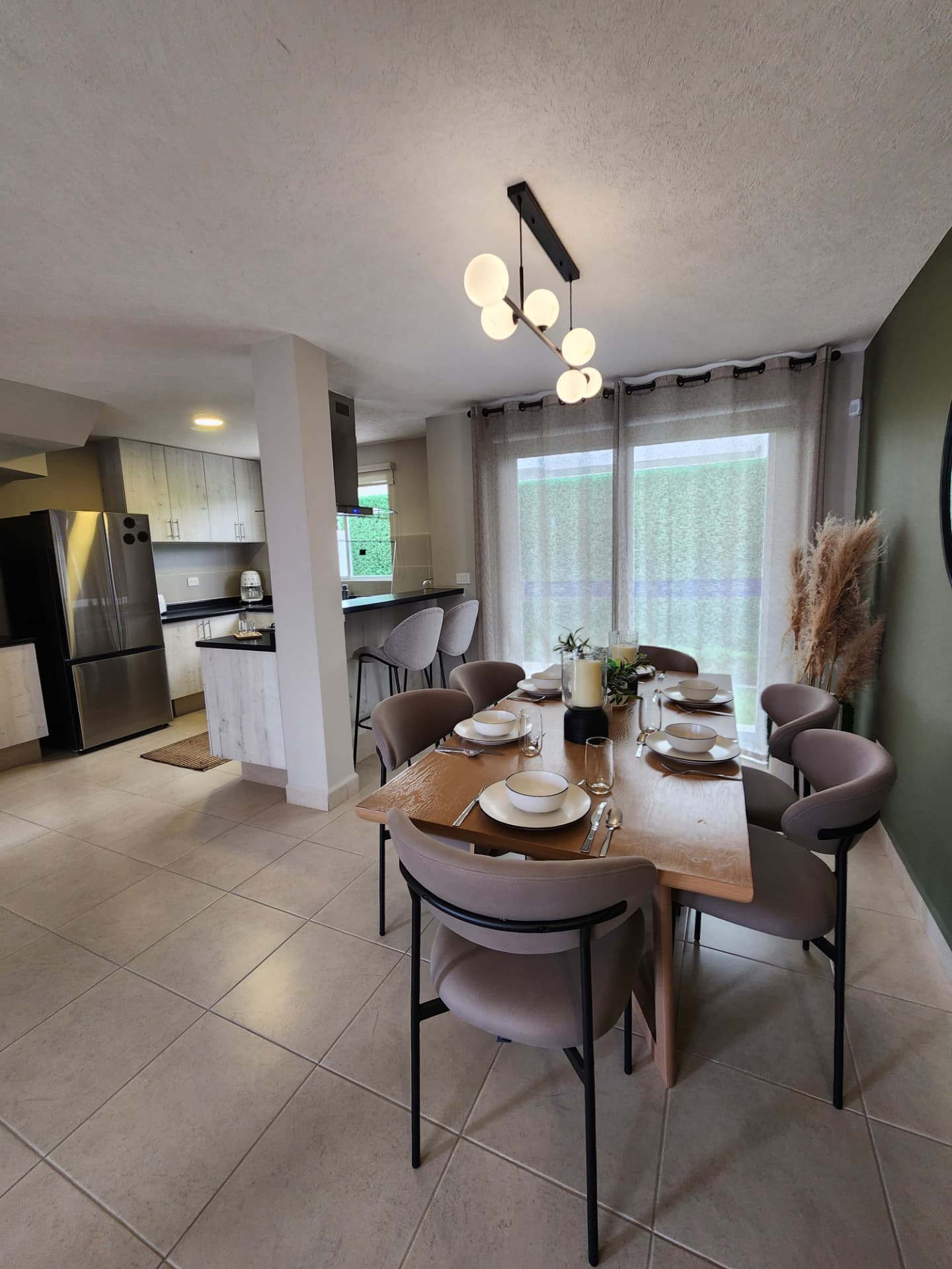 Comedor amueblado con vista al jardín, integrado a cocina con barra