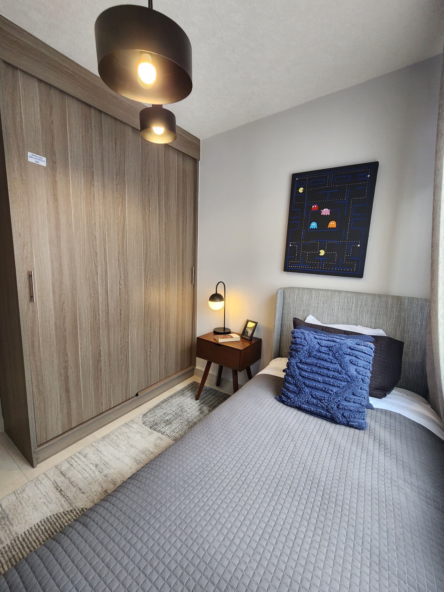 Recámara amueblada con closet de piso a techo e iluminación decorativa