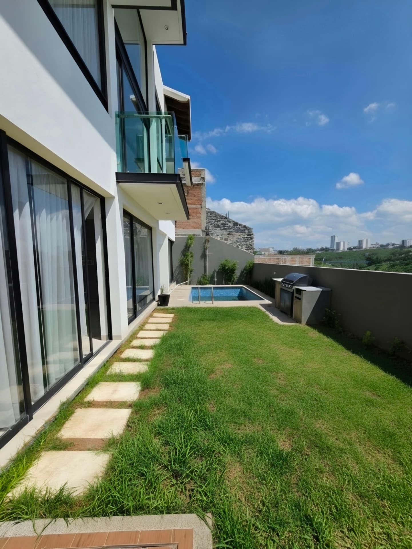 Jardín con alberca y asador