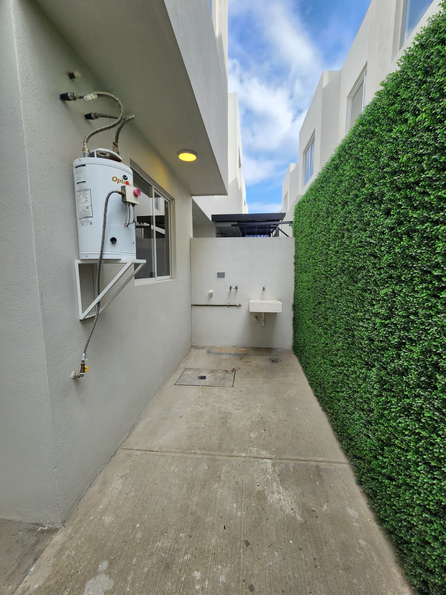 Patio de servicio con boiler, lavadero y muro verde