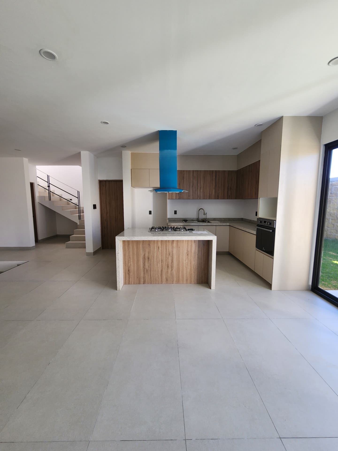Cocina equipada abierta a la estancia con isla central y salida al jardín
