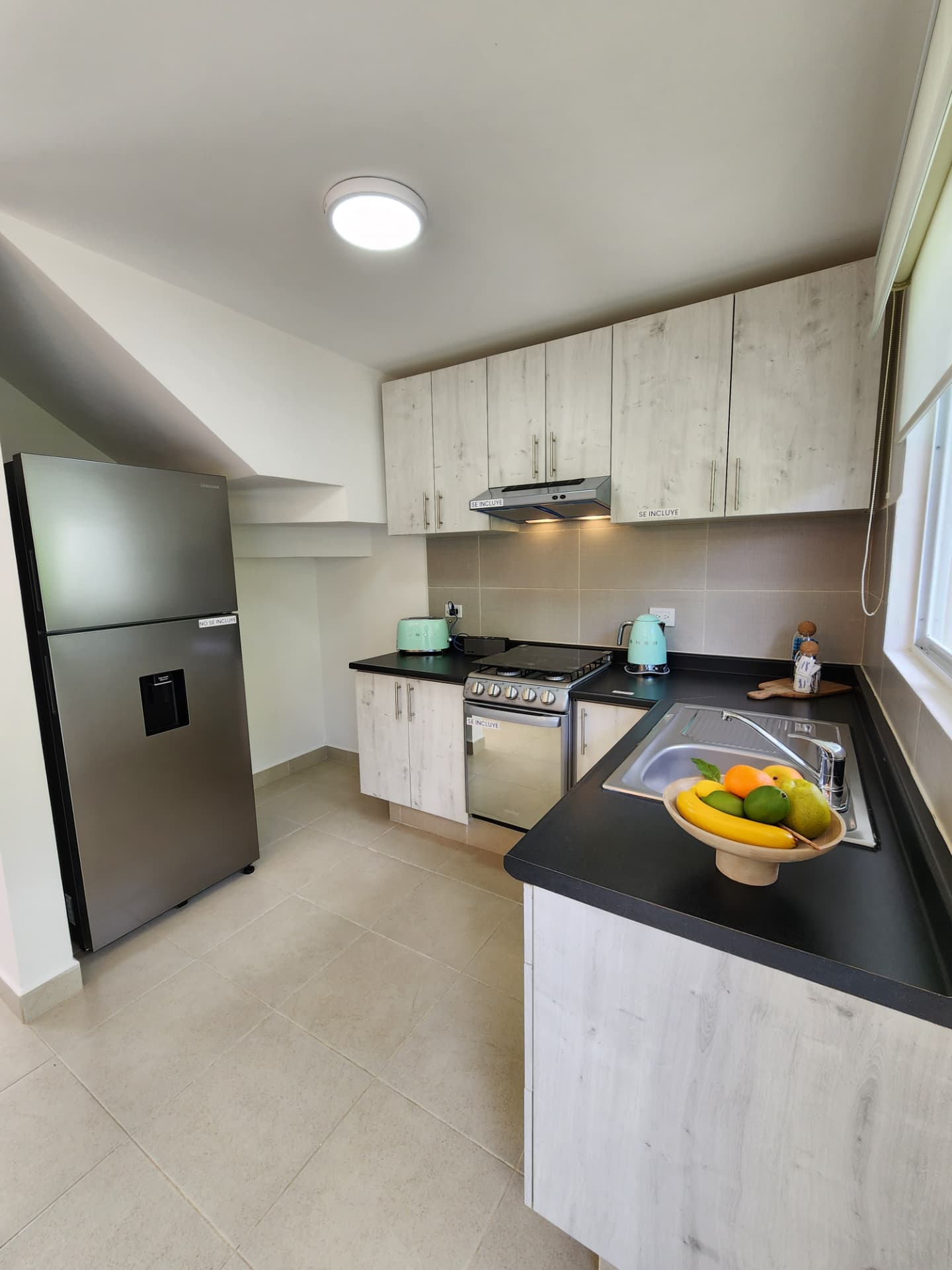 Cocina equipada con parrilla, campana y barra