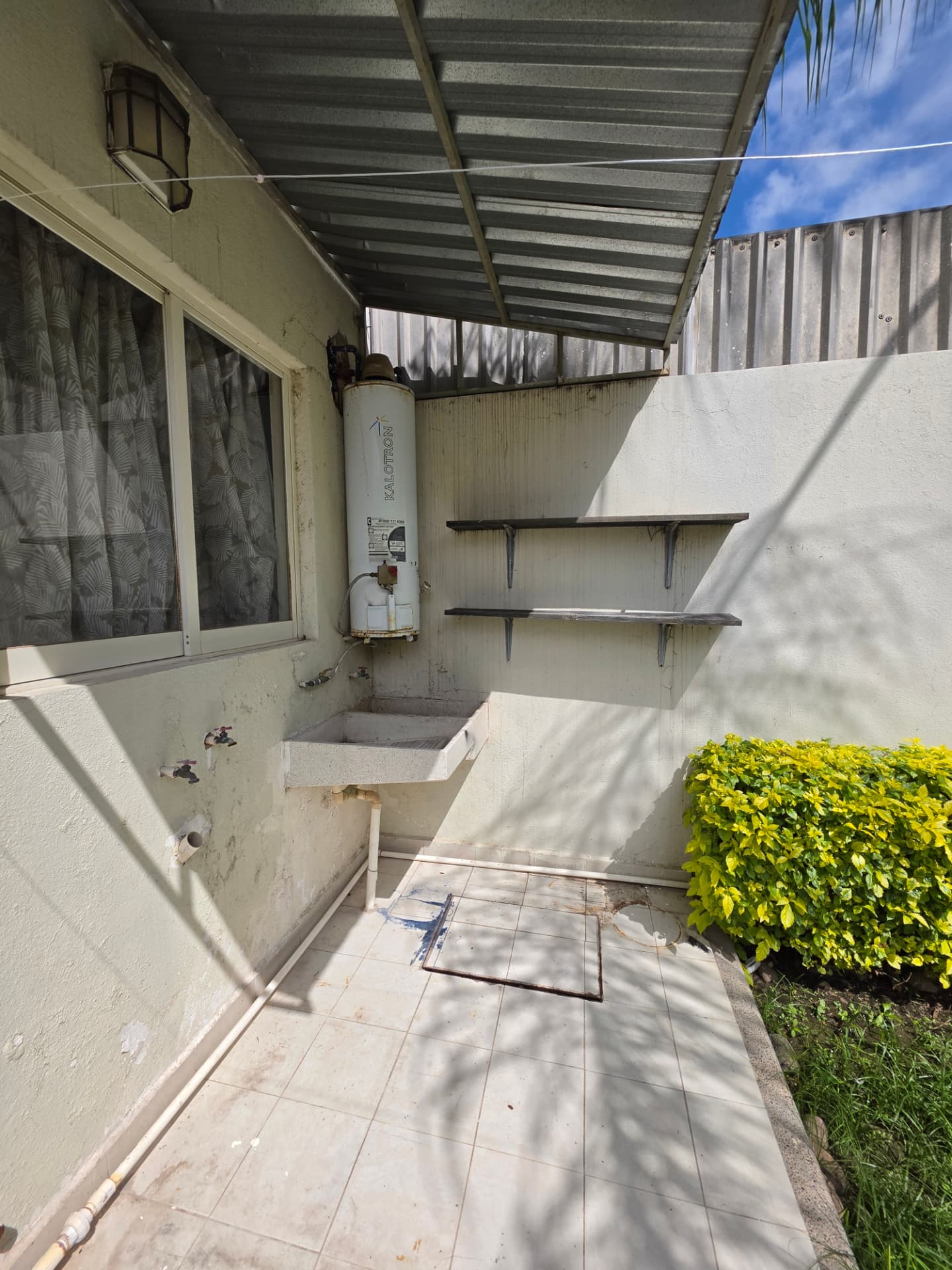 Patio de servicio techado con lavadero, boiler y área de tendido