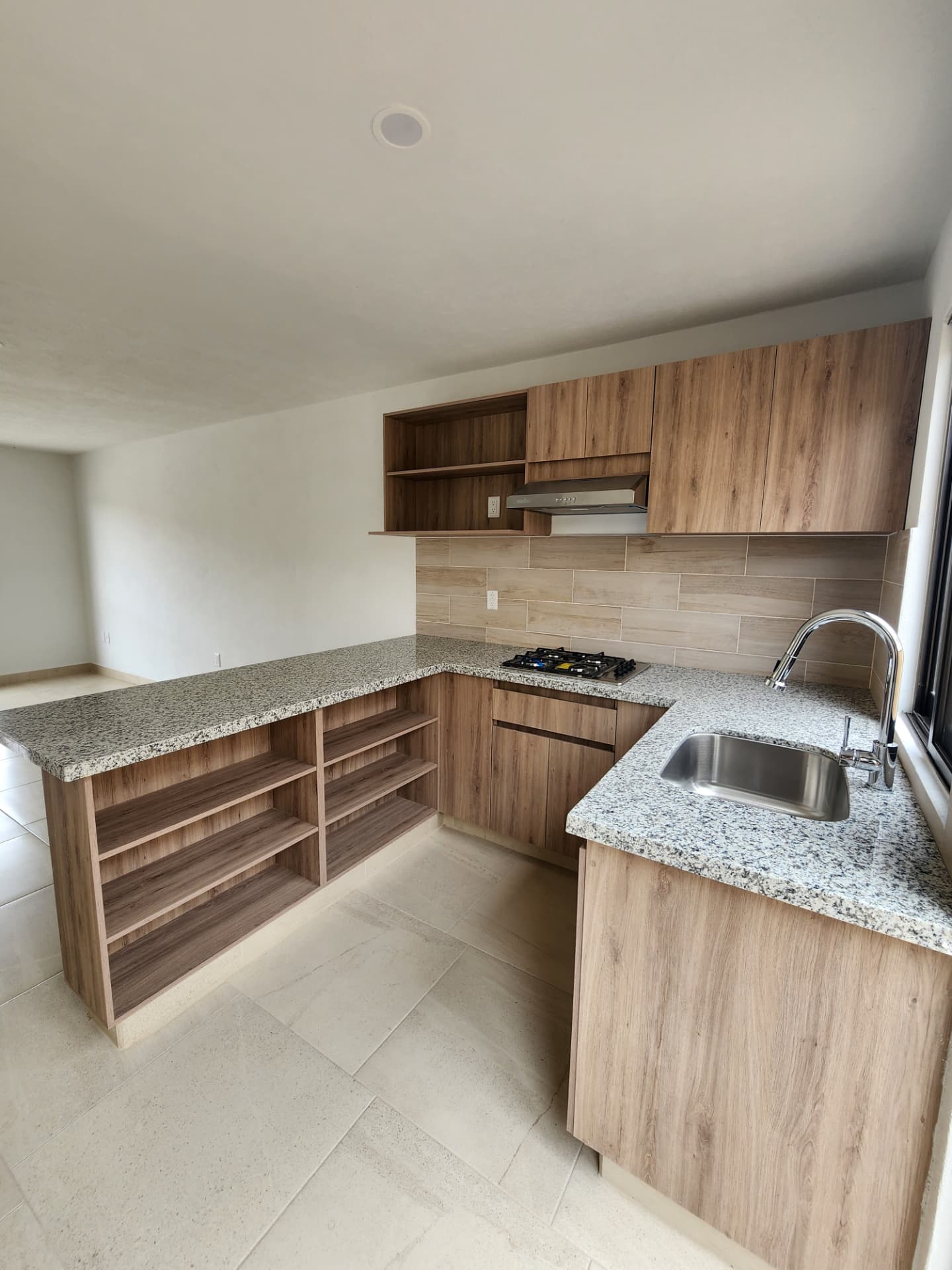 Cocina con barra de granito, tarja y repisas de madera