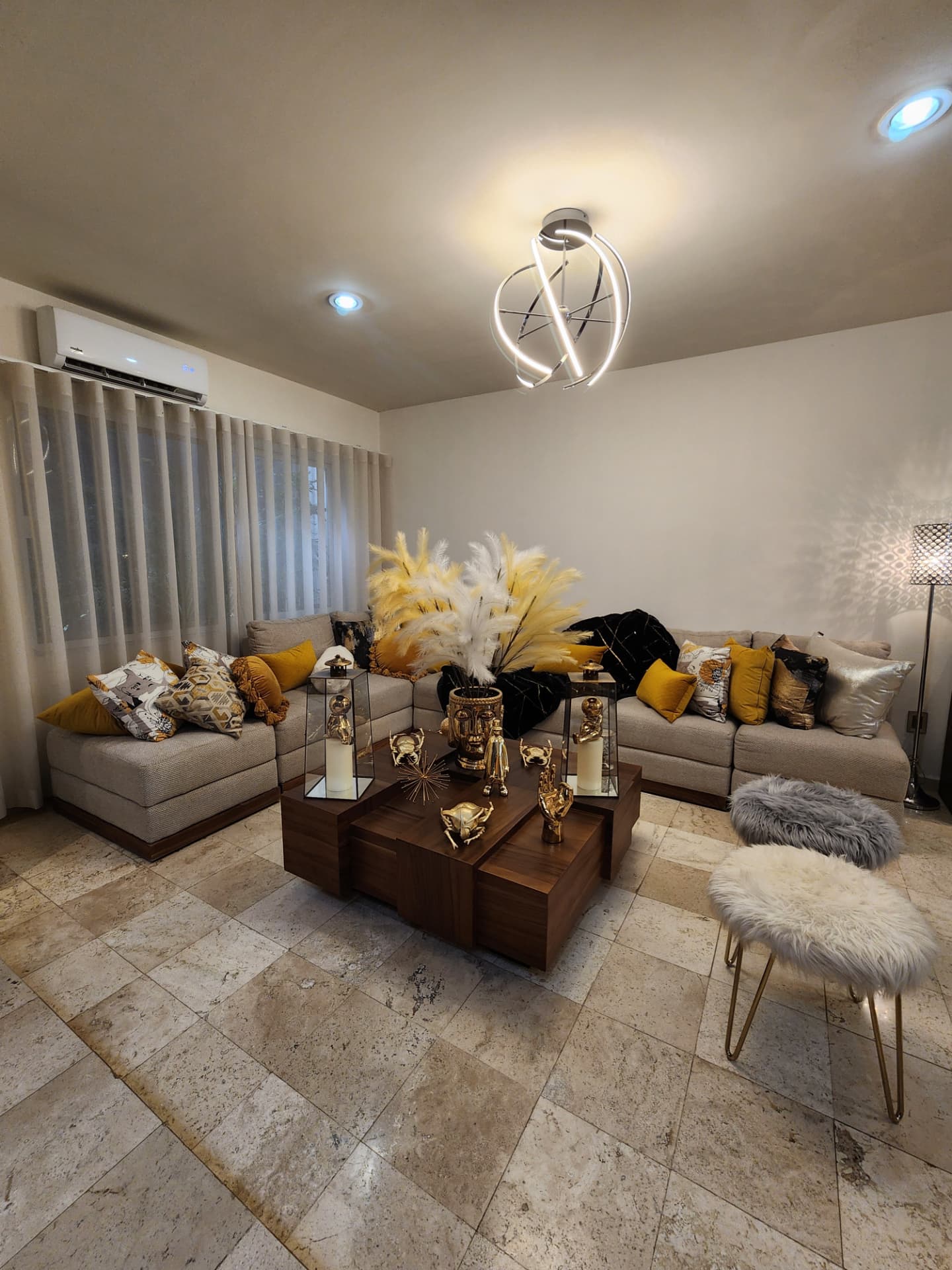 Sala con minisplit, cortinas de piso a techo y piso de mármol
