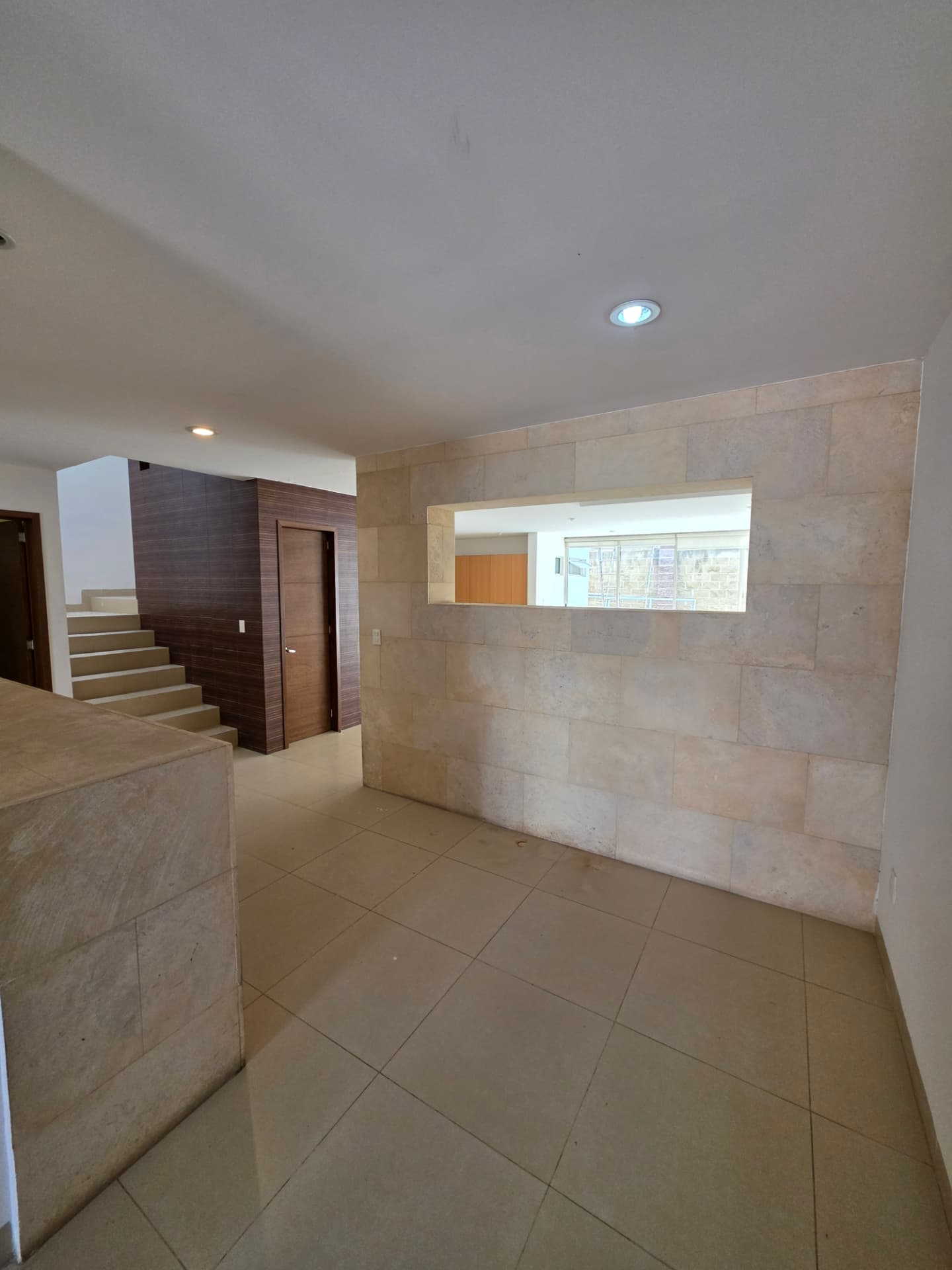 Recibidor con muro de cantera y escaleras