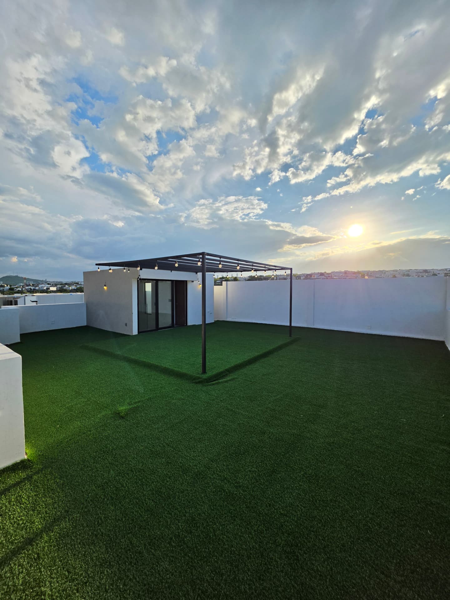 Roof top con pasto sintético, pérgola metálica con luces y vista panorámica