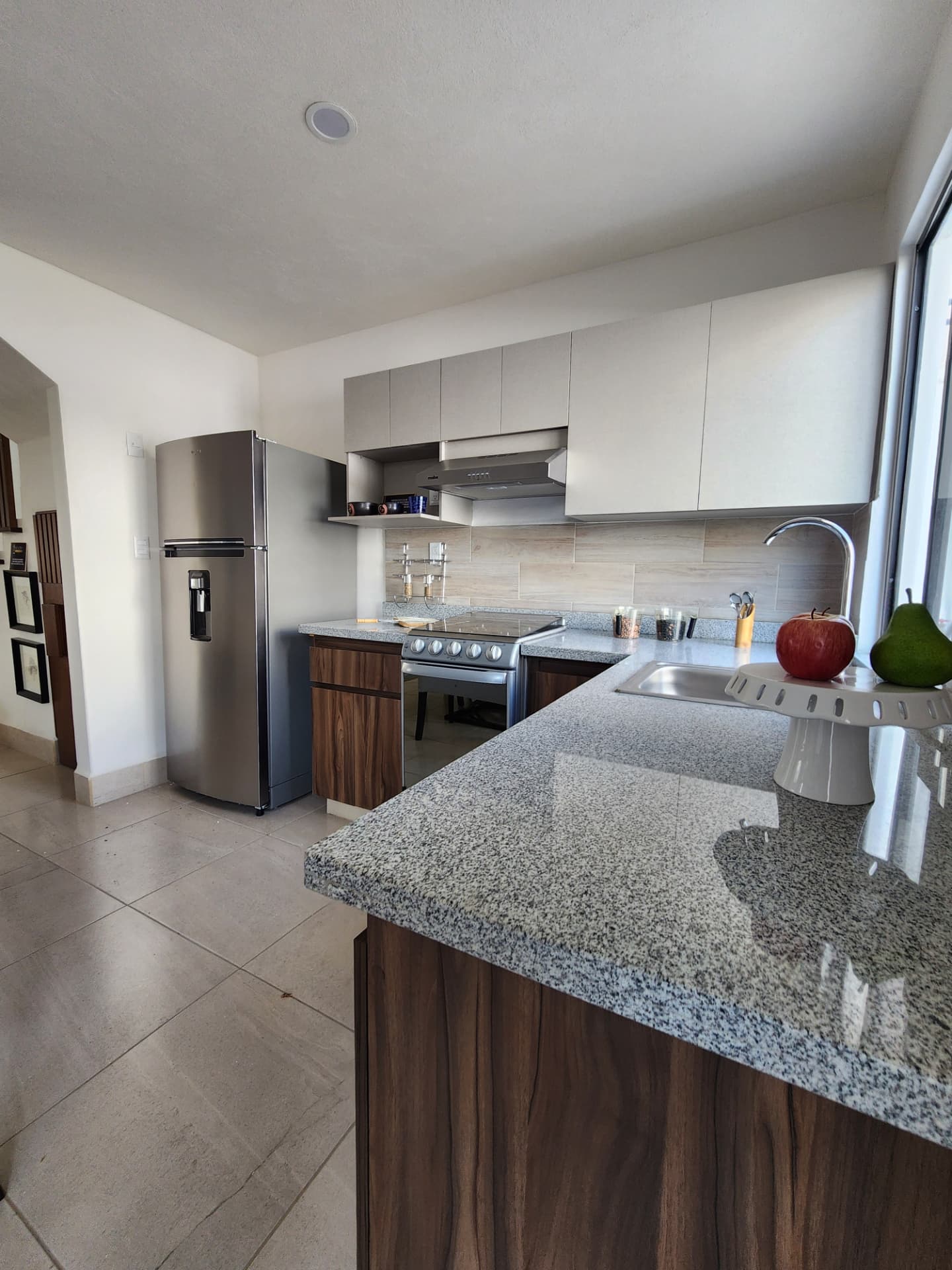 Cocina equipada con cubierta de granito y refrigerador