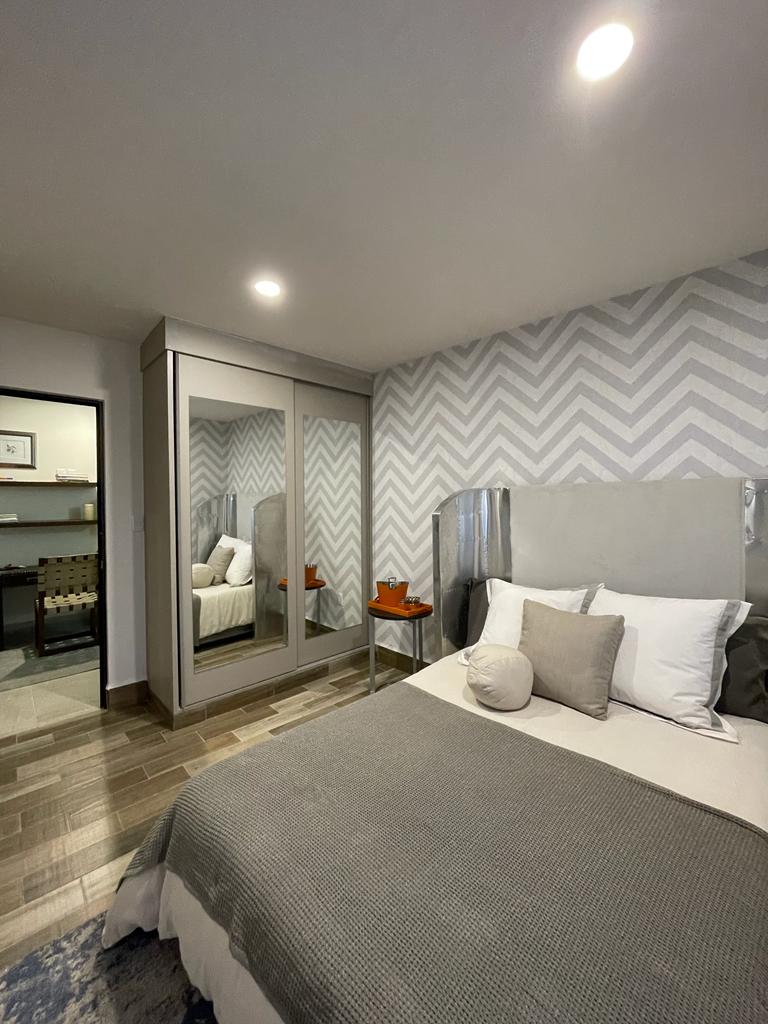 Recámara con closet de puertas espejo y baño completo
