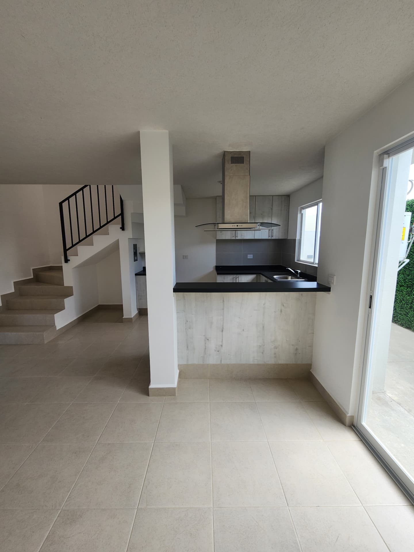 Sala / comedor integrado a la cocina con barra y salida al jardín