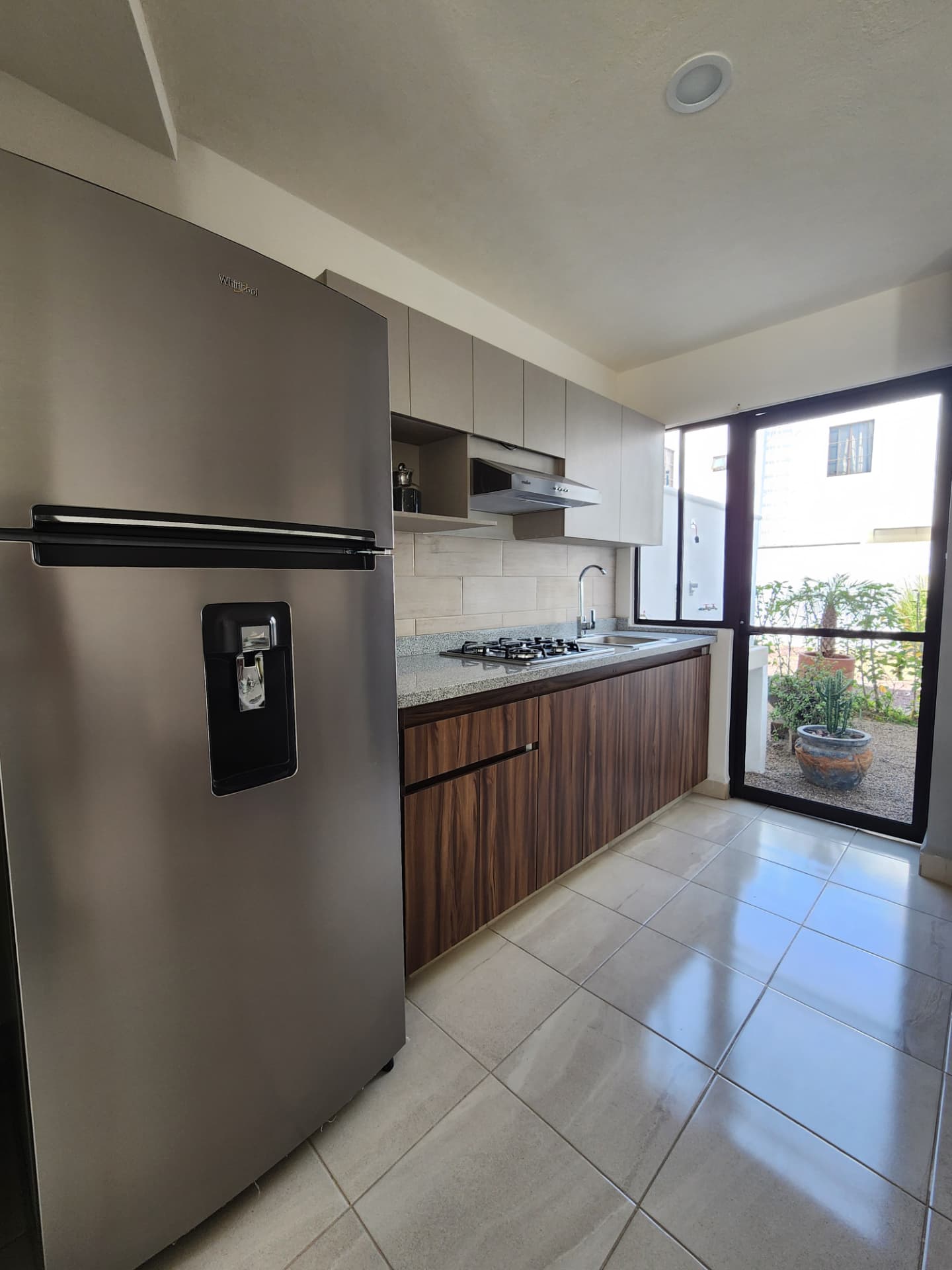Cocina equipada con cubierta de granito y refrigerador