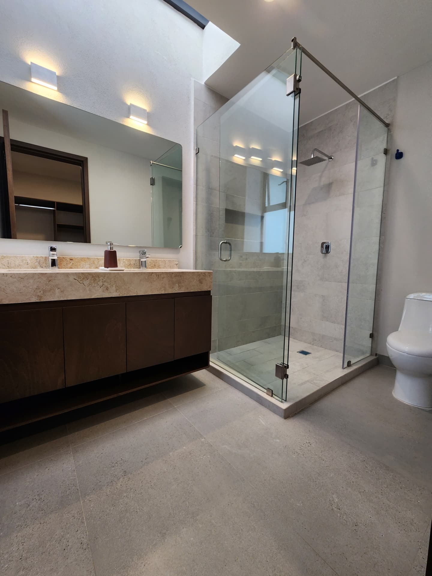 Baño principal con doble lavabo y regadera de cristal