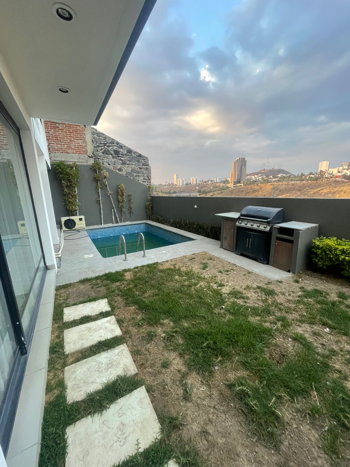 Jardín con alberca y asador