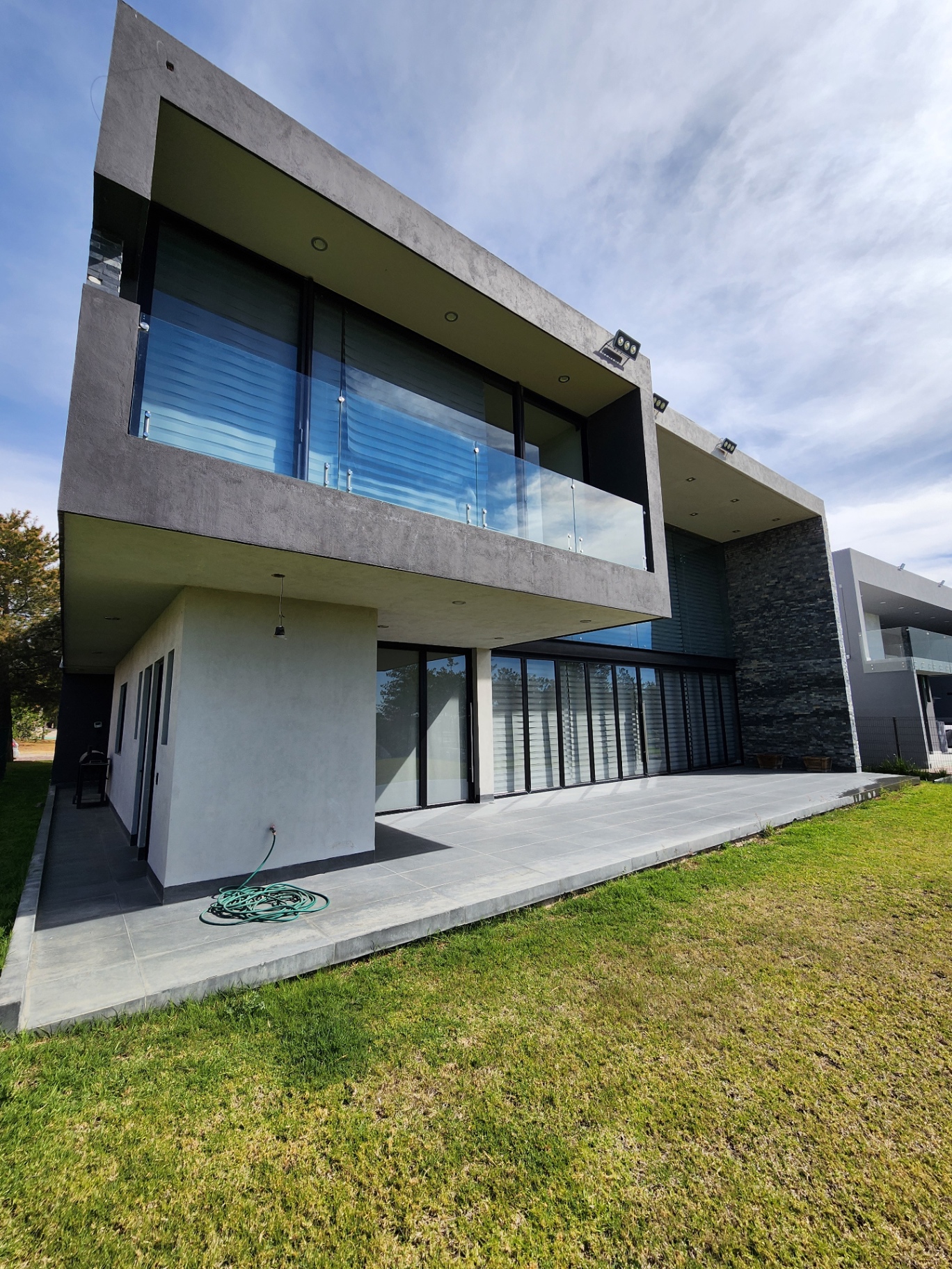 Fachada posterior con terraza y balcón en voladizo