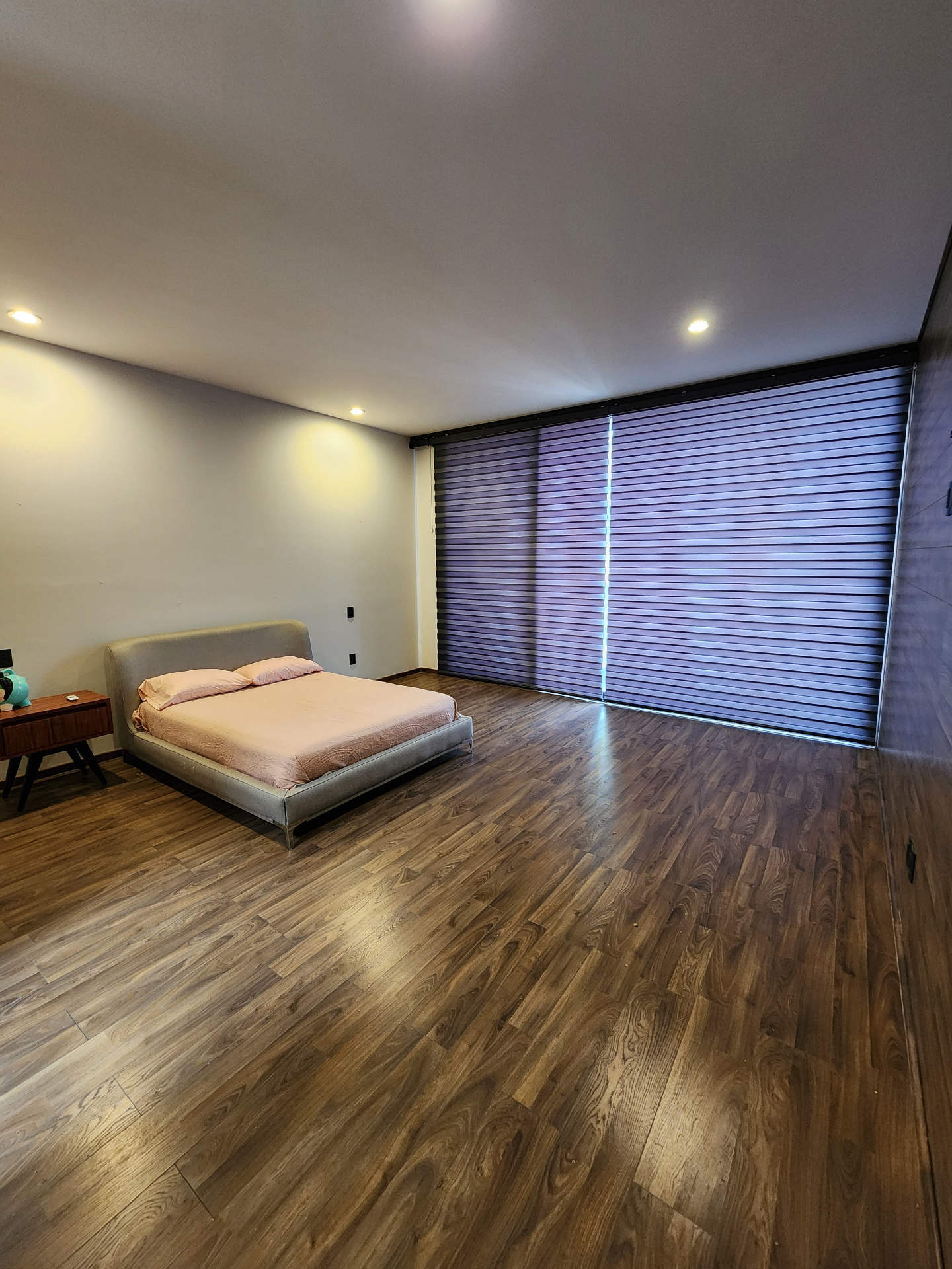 Recámara con persianas duo y piso de madera